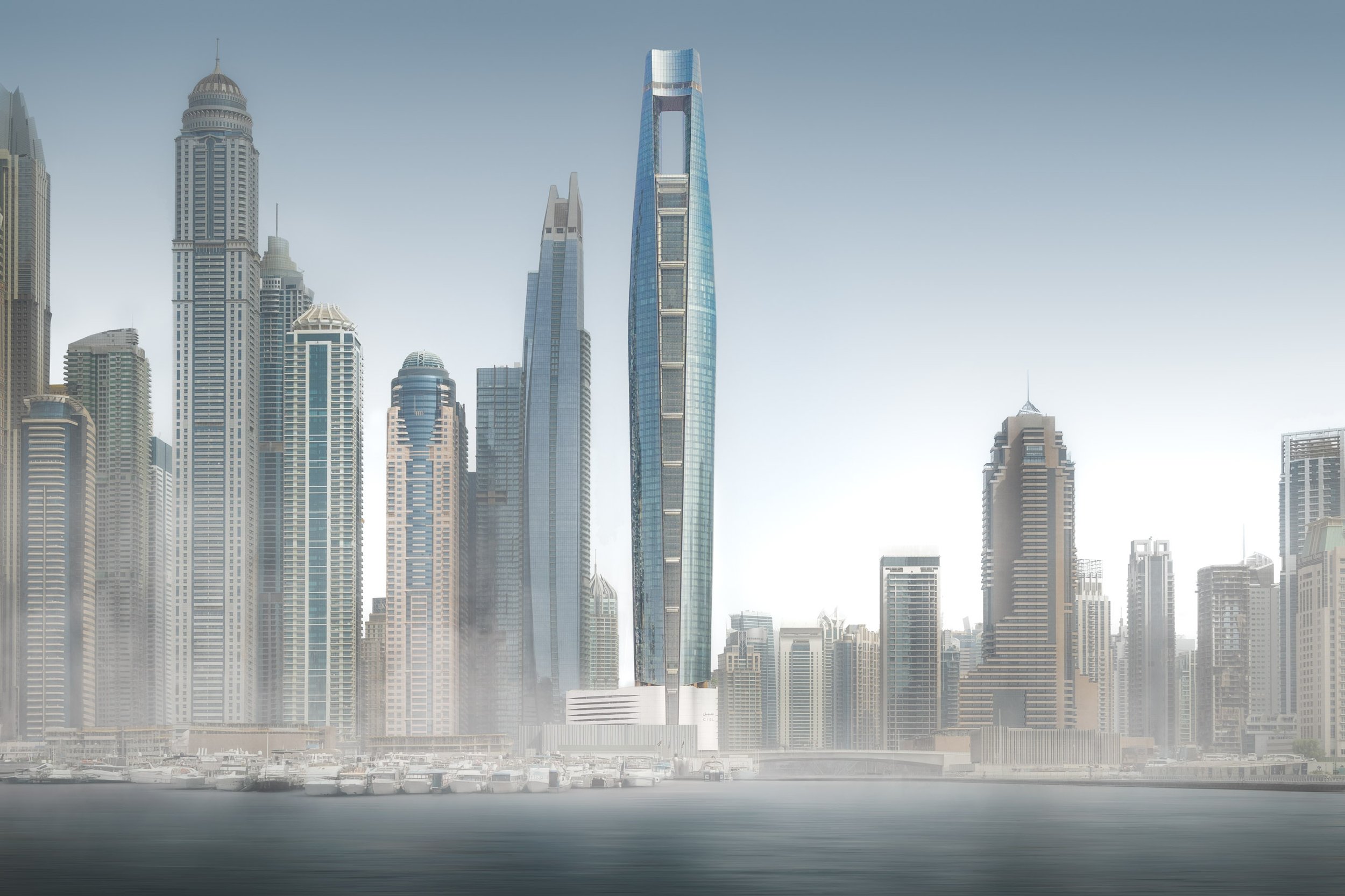 Ciel Dubai Marina by NORR standing above the Dubai Marina skyline in fog, the marina and its boats fading into white.