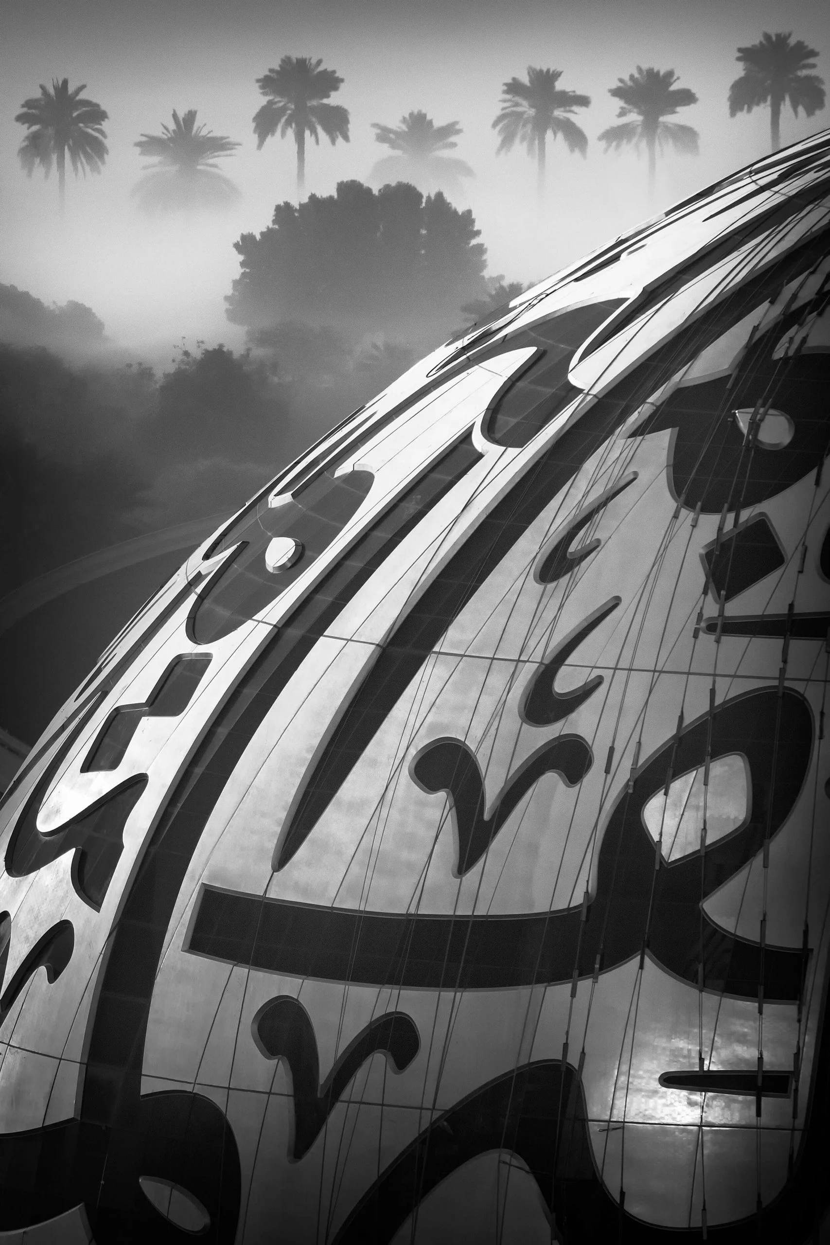 Museum of the Future Arabic calligraphy facade in black and white with palm trees and fog — fine art architectural photograph by Ahmad Alnaji, SARAB Art Production