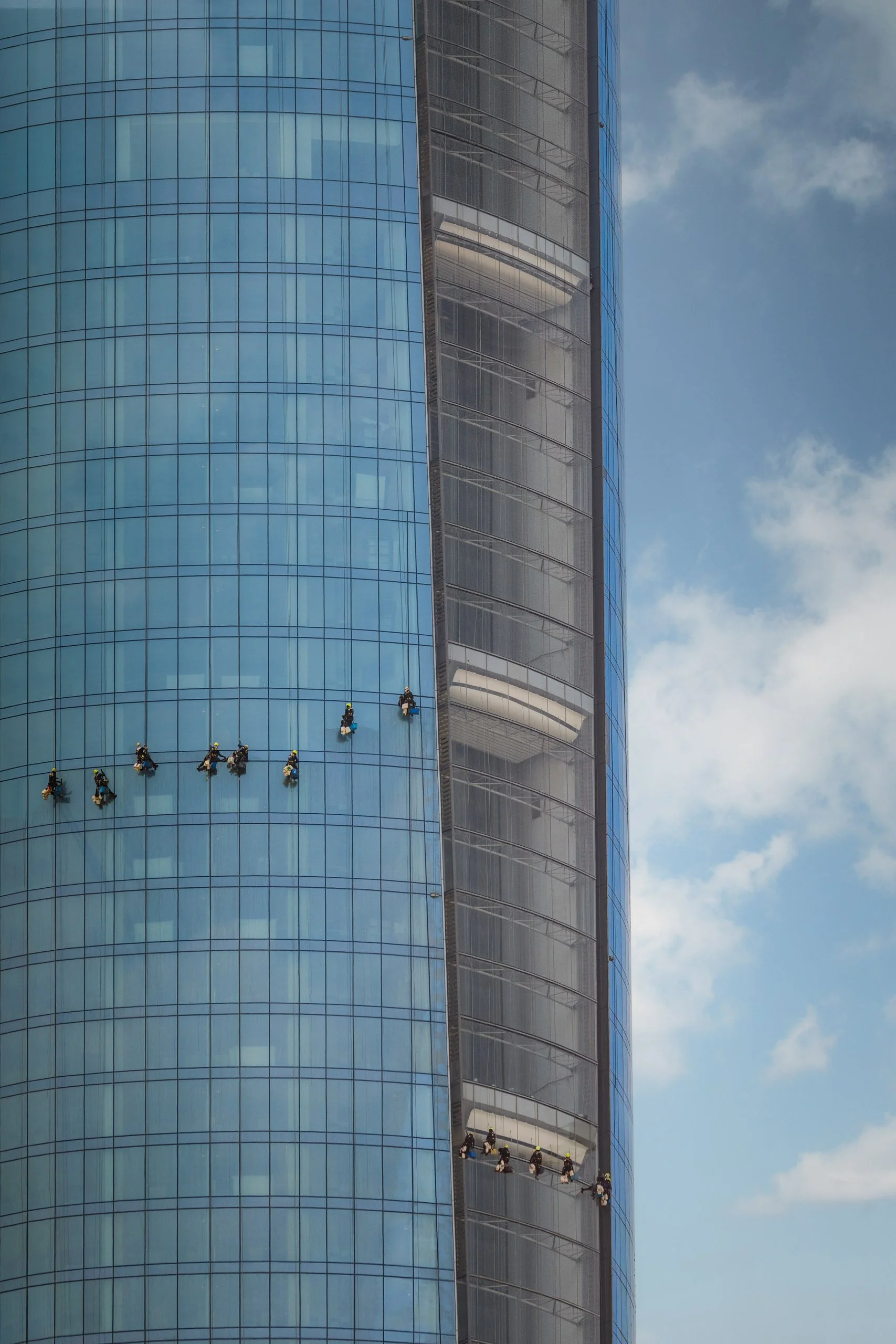 A rope access team working down the glass facade of Ciel Dubai Marina.