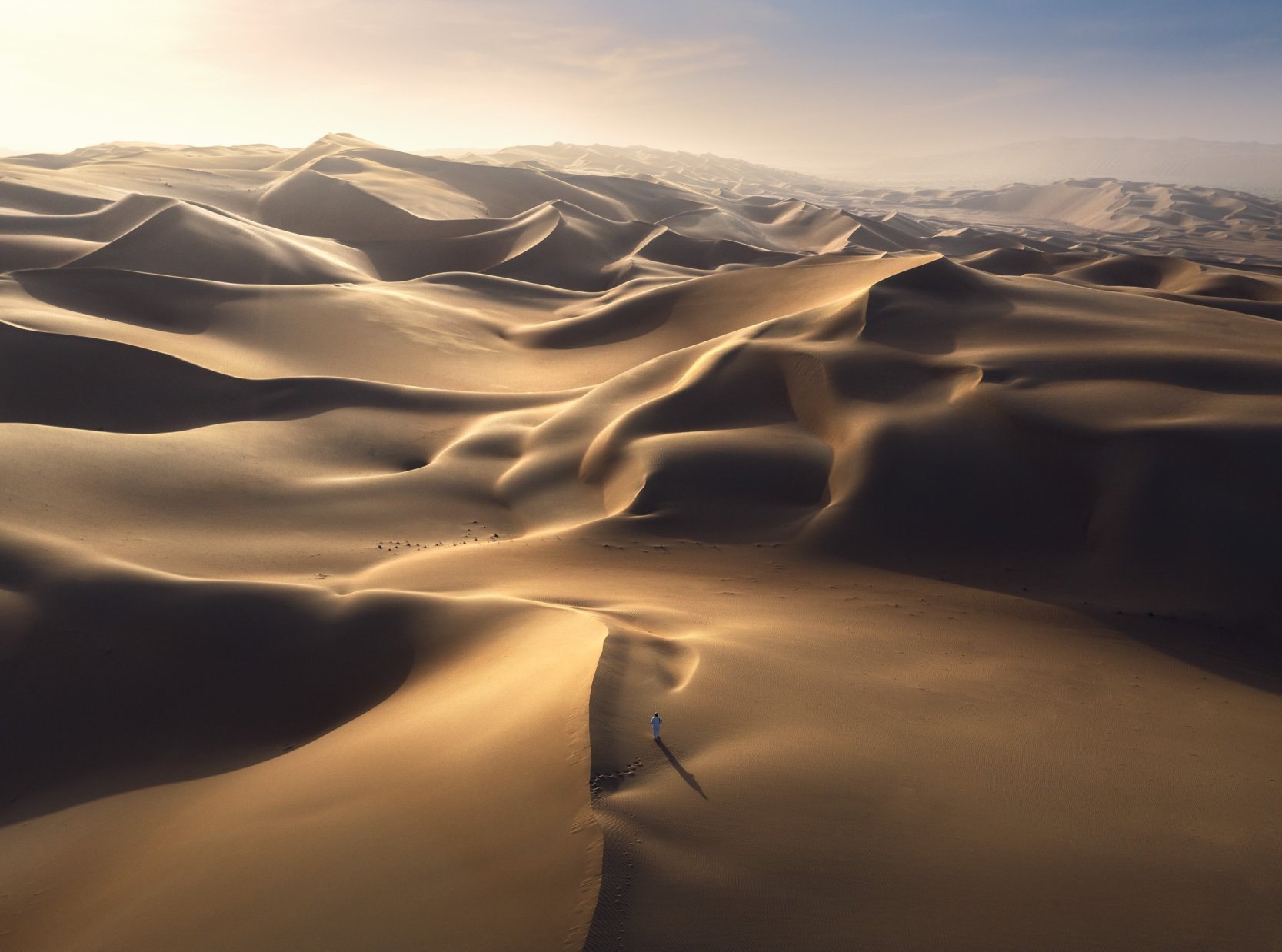 lone-figure-walking-vast-golden-sand-dunes-uae-sarab.jpg