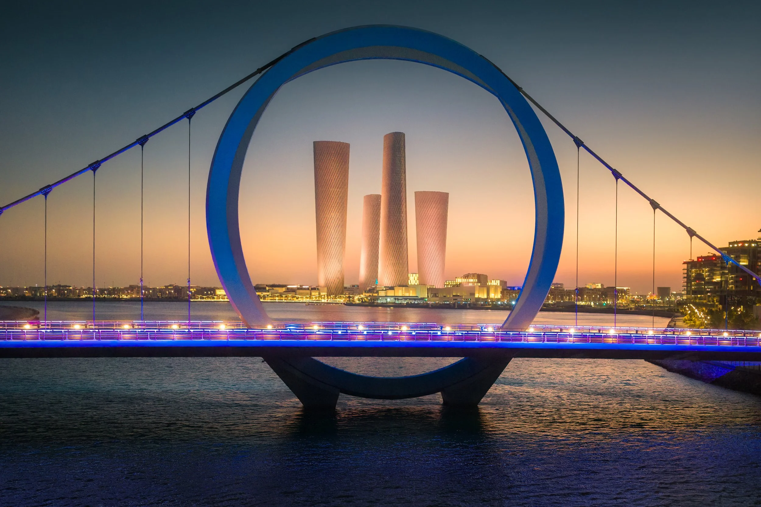 Doha at sunset and Lusail towers, designed by Foster + Partners and developed by Qatari Diar, seen through Lusail bridge - fine art architectural photograph by Ahmad Alnaji, SARAB Art Production