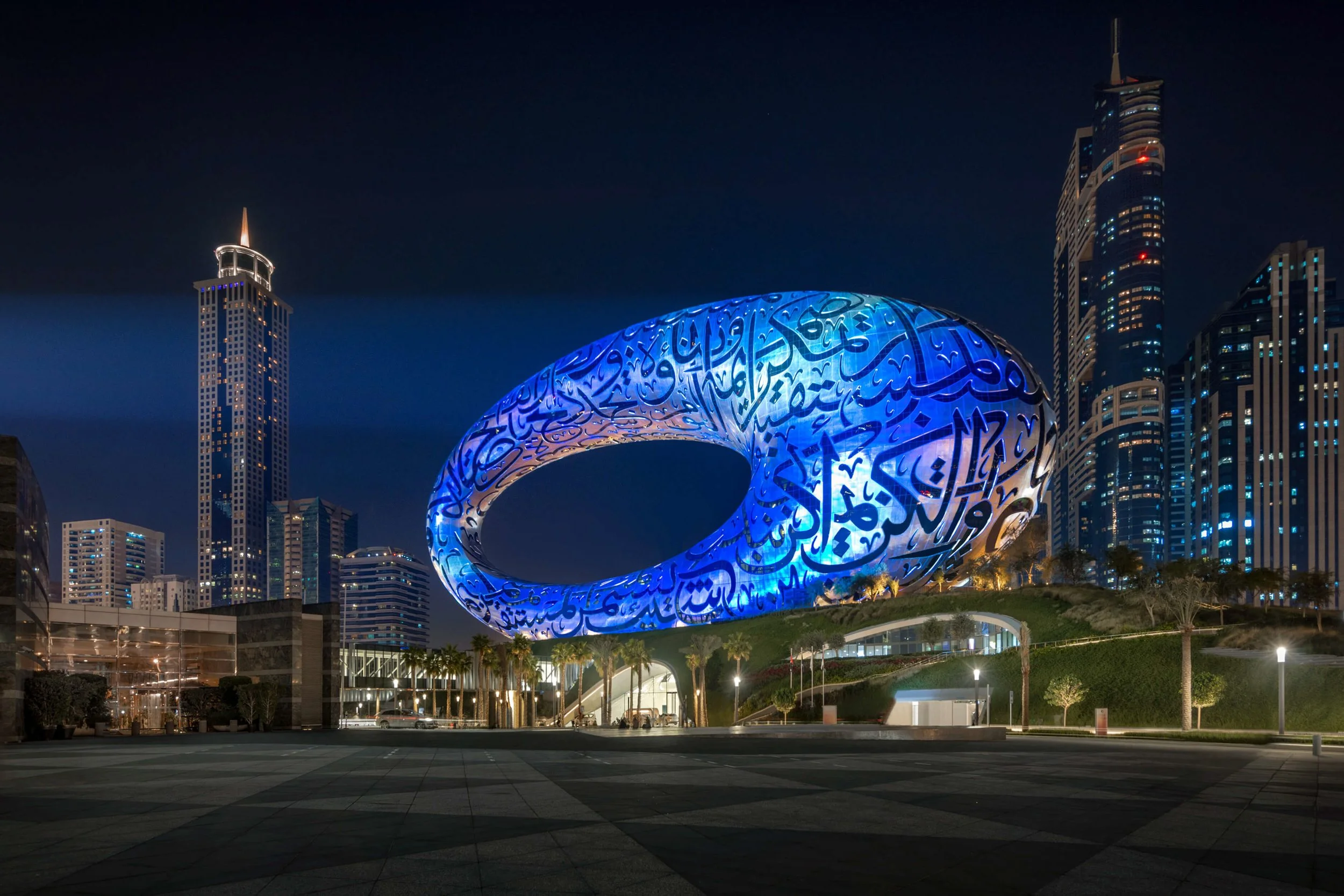 Museum of the Future illuminated in blue at night with Dubai Financial District skyline — fine art architectural photograph by Ahmad Alnaji, SARAB Art Production