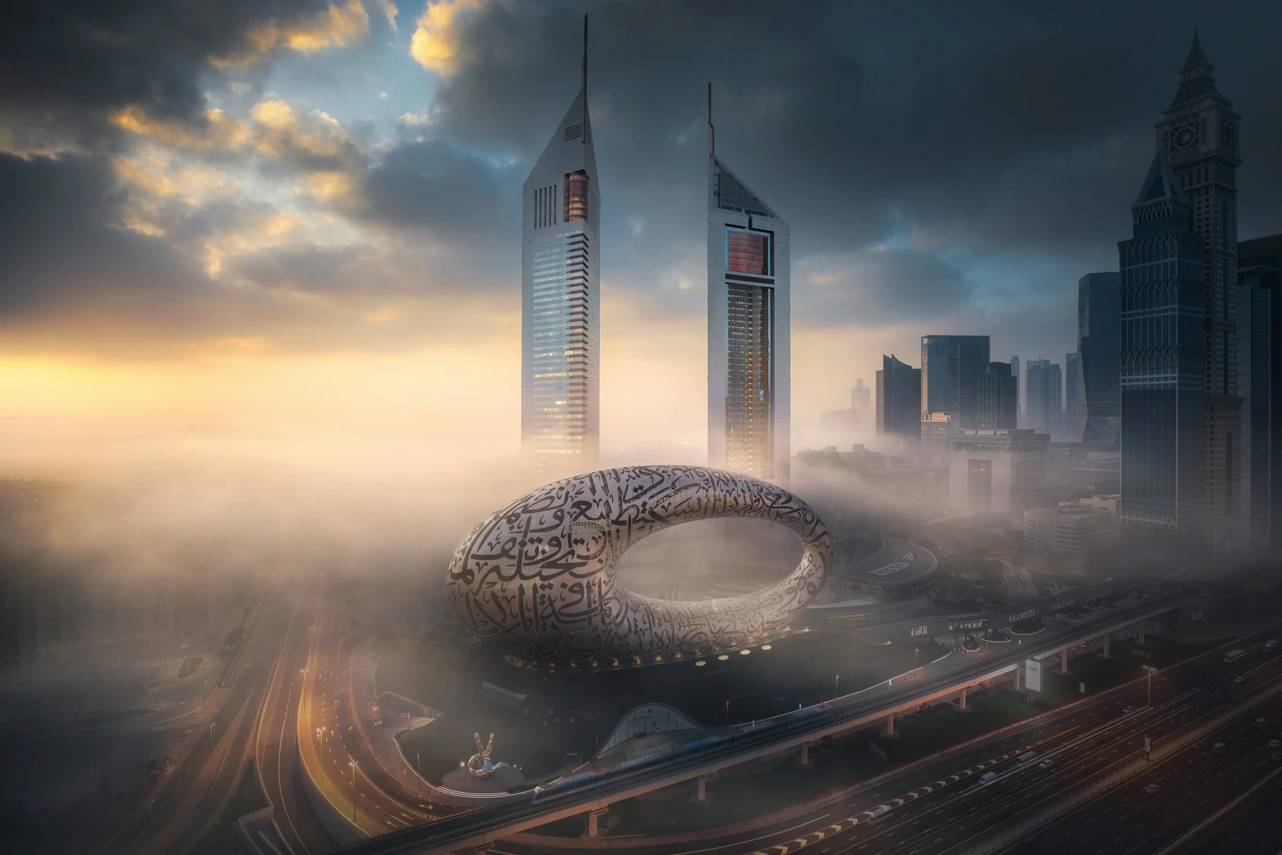 City skyline at dusk featuring tall skyscrapers, a futuristic circular structure with Arabic calligraphy, and a highway with lights below.