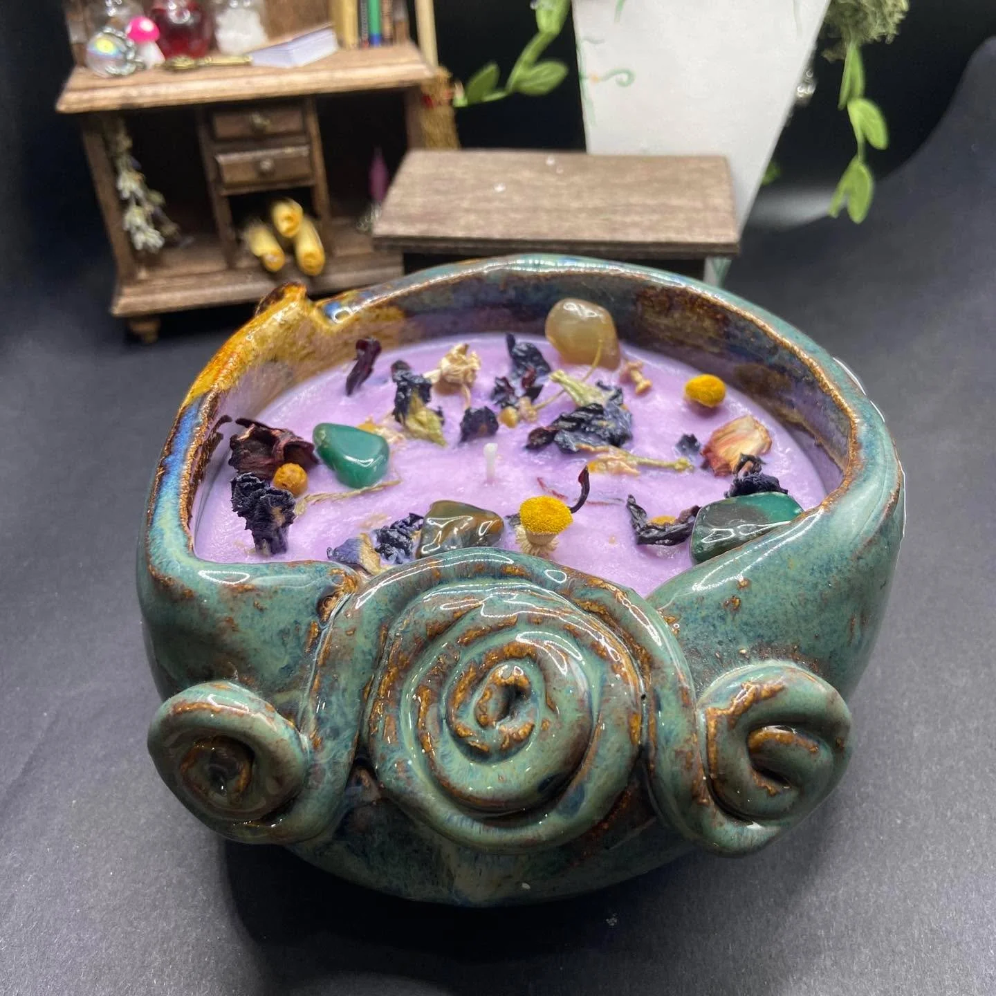 Made from someone&rsquo;s handmade ceramic bowl found at a thrift store, this grape scented candle is a personal favorite. 

With crystals to match the glaze on the bowl and Chamomile and Butterfly Pea Tea to contrast from the fair purple color, this