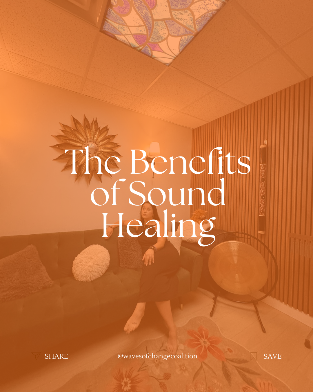 A woman sitting on a sofa in a cozy living room with wooden wall paneling, a decorative sun wall art, a table lamp, a large gong, and hanging wall art. The text on the image reads 'The Benefits of Sound Healing'.