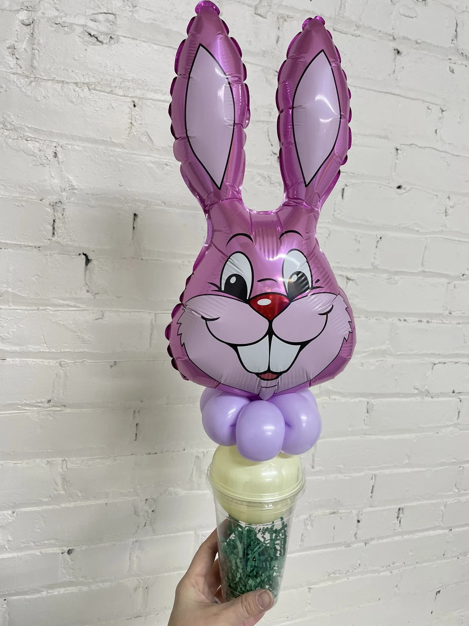 Small foil balloon shaped like a bunny on top of a plastic cup