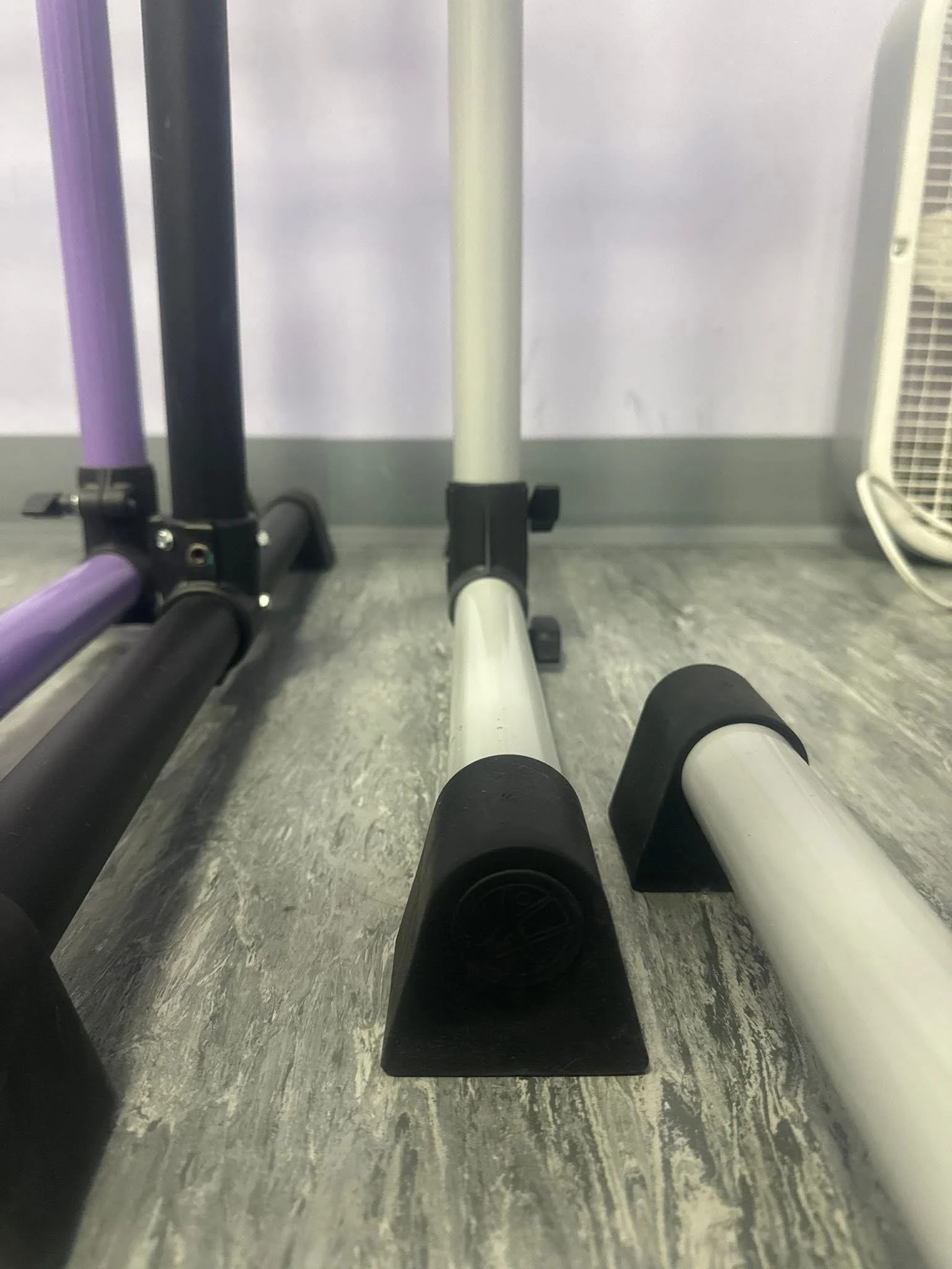Close-up of three flat exercise benches or platforms with black rubber legs, in a fitness or gym setting.