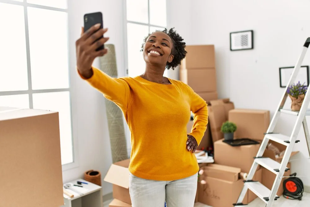 woman-taking-selfie-with-cardboard-boxes-in-new-home.jpg