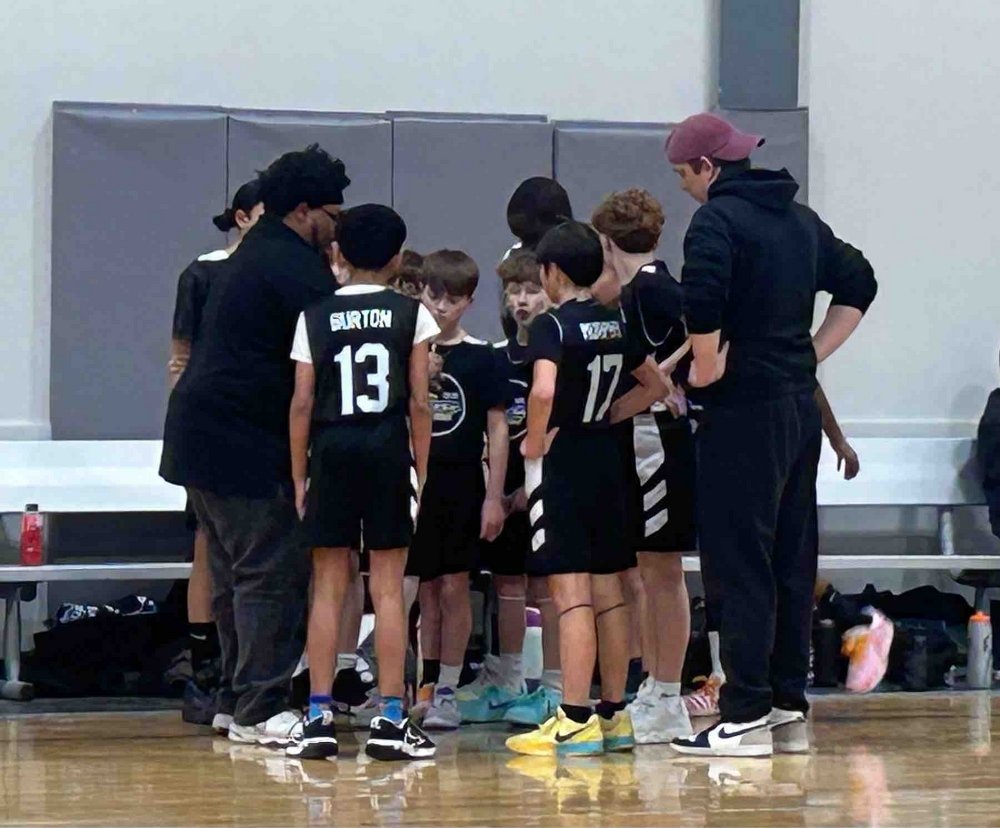 NBA team huddle during a game, coach drawing up the play