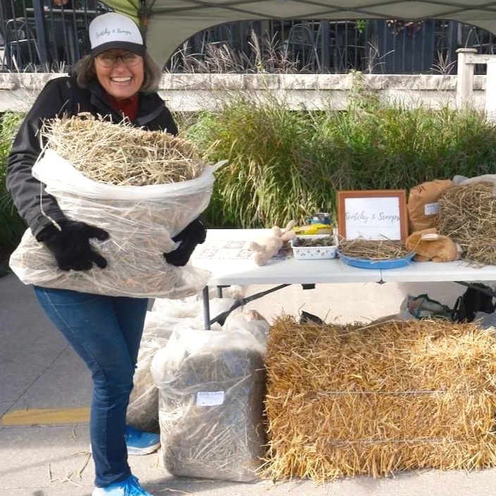 Woman holding a large bag of Timothy Hay