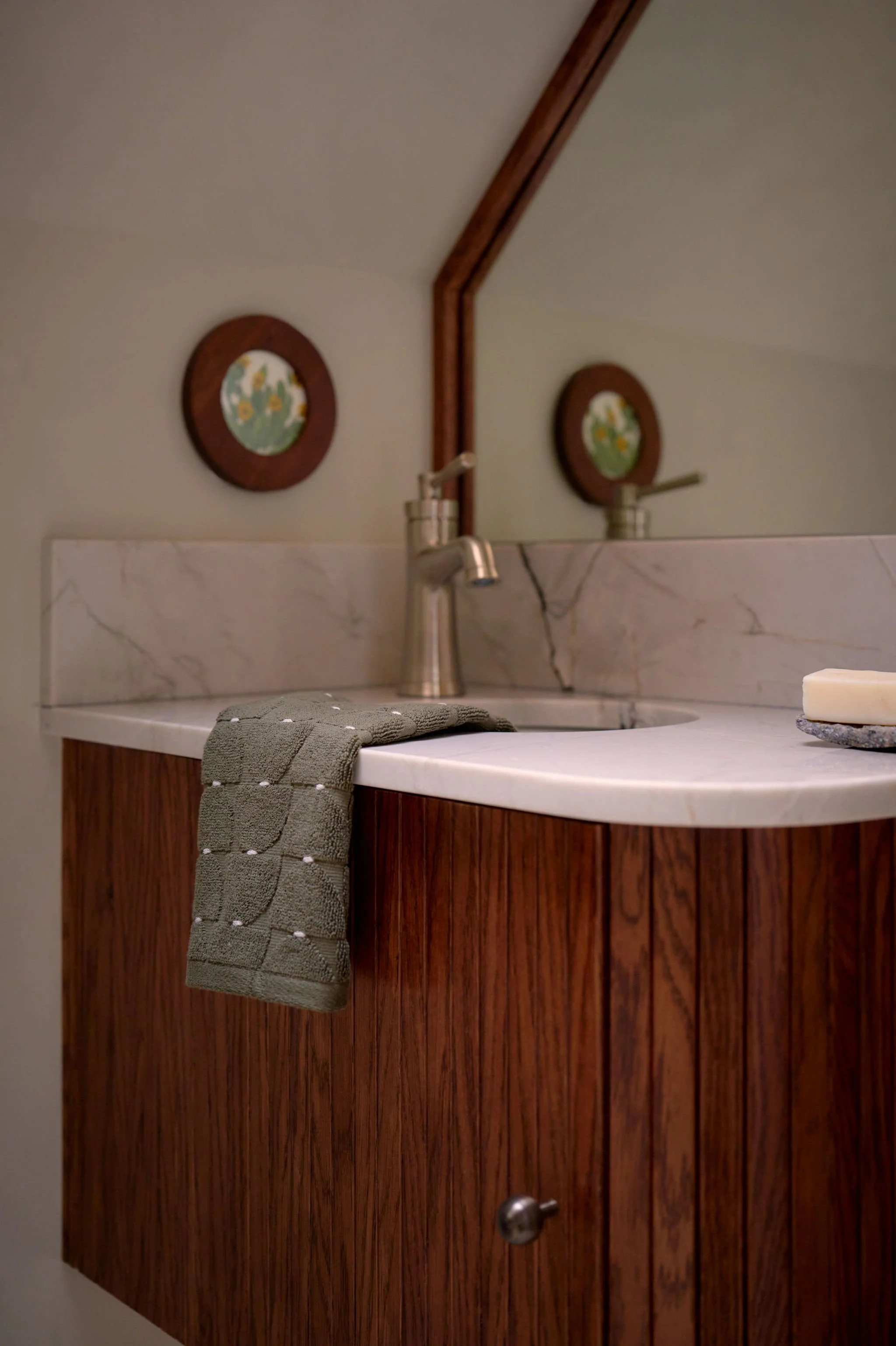 Close up of  Curved Vanity in small Tahoe Bathroom with Dark Wood, Plaster, and stone  by Andrea Lackie Design