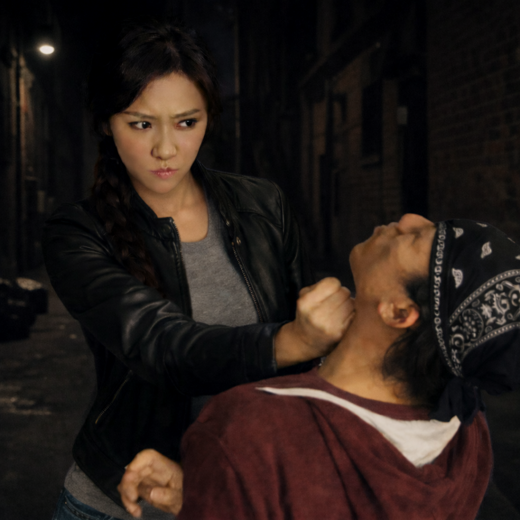 A woman using wing chun for self defense in a dark alley.