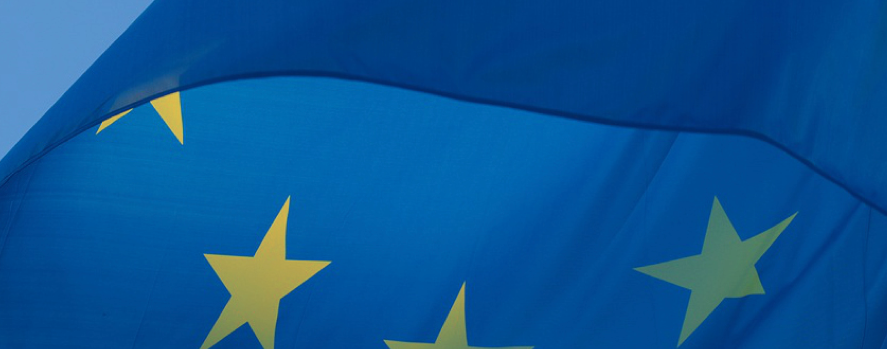 Close-up of the European Union flag with blue background and yellow stars.