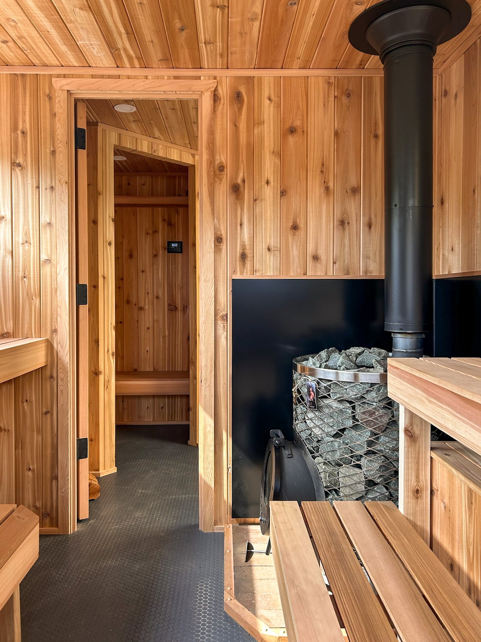 Sauna seating and wood-fired stove with stones
