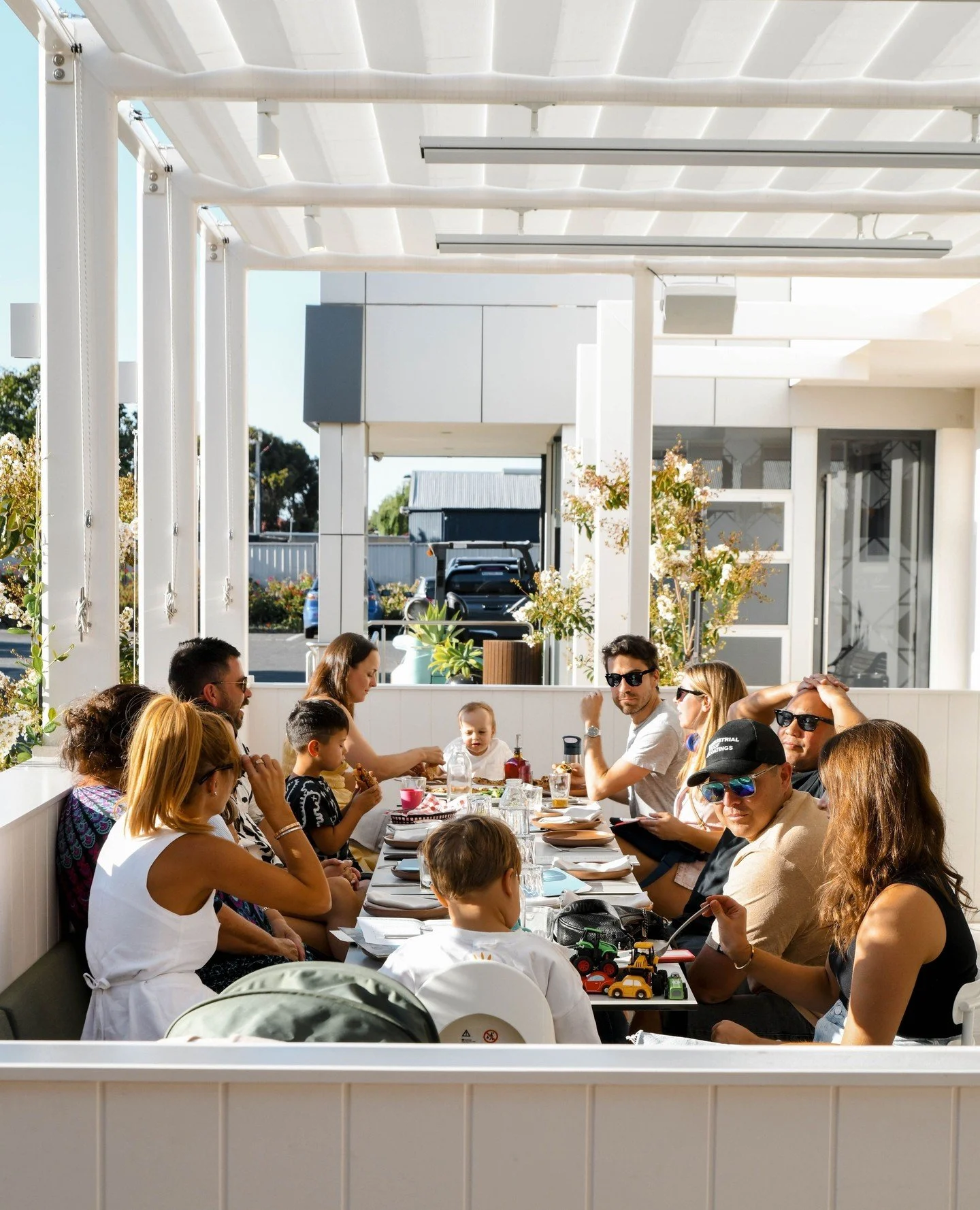 Community groups enjoying the fundraiser with drinks and pizza outside at Bobbi's