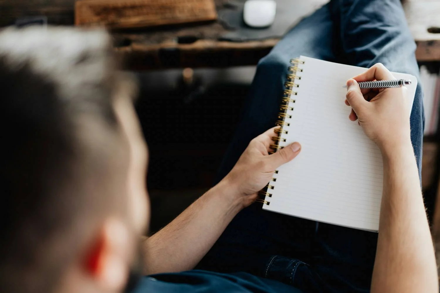 Therapist writing in spiral notebook during individual therapy session for toxic relationship counseling in Mooresville, NC.