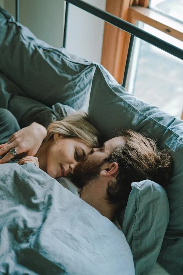 A couple lying close together, foreheads touching, representing the closeness that's possible once a man stops managing a relationship and starts actually fixing what's underneath