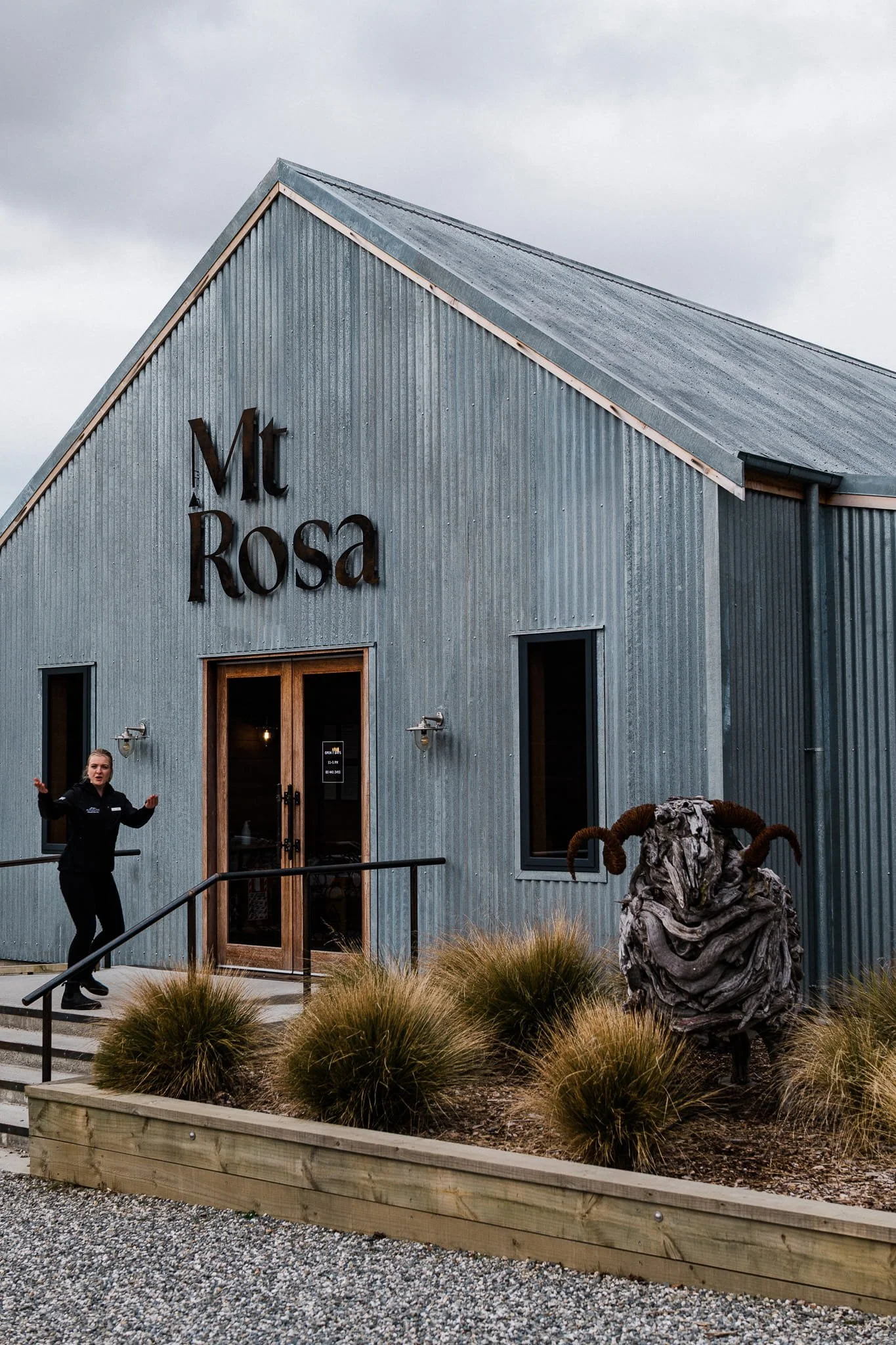 Exterior of Mt Rosa winery building with corrugated iron facade and ram sculpture, Gibbston Valley