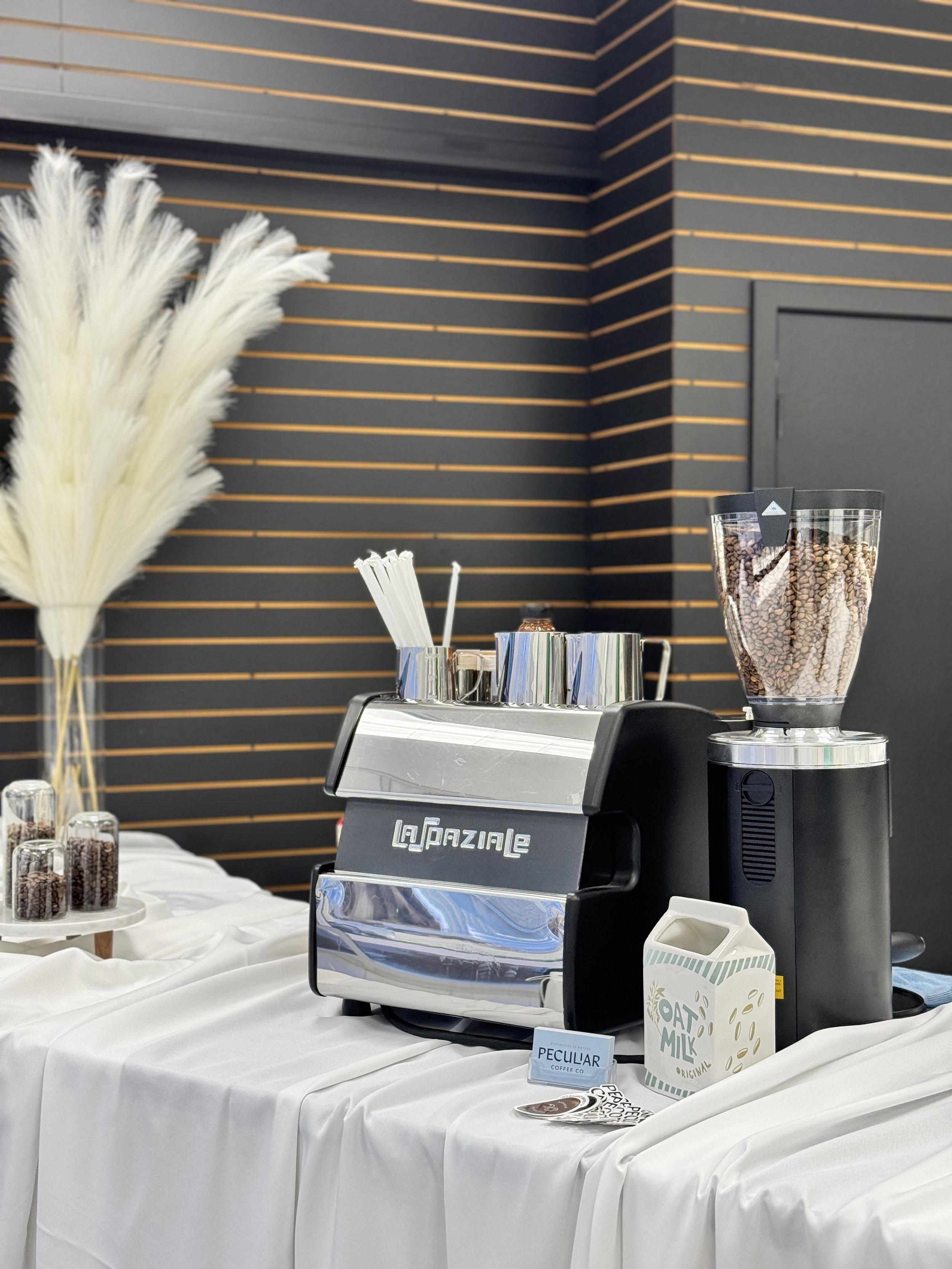 A mobile espresso bar, set up on a counter with a white linen drape.