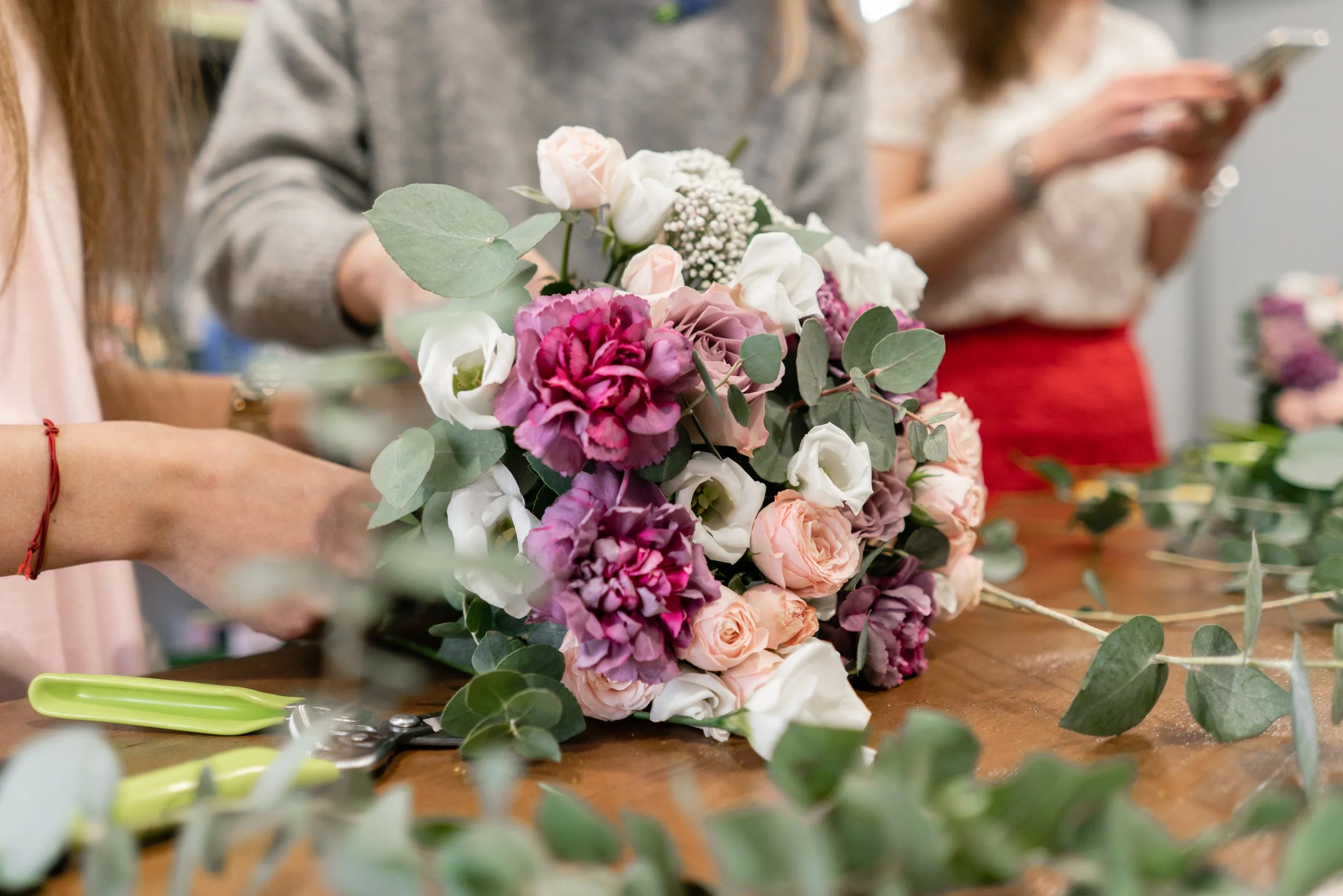 Women around a design table making flower bouquets