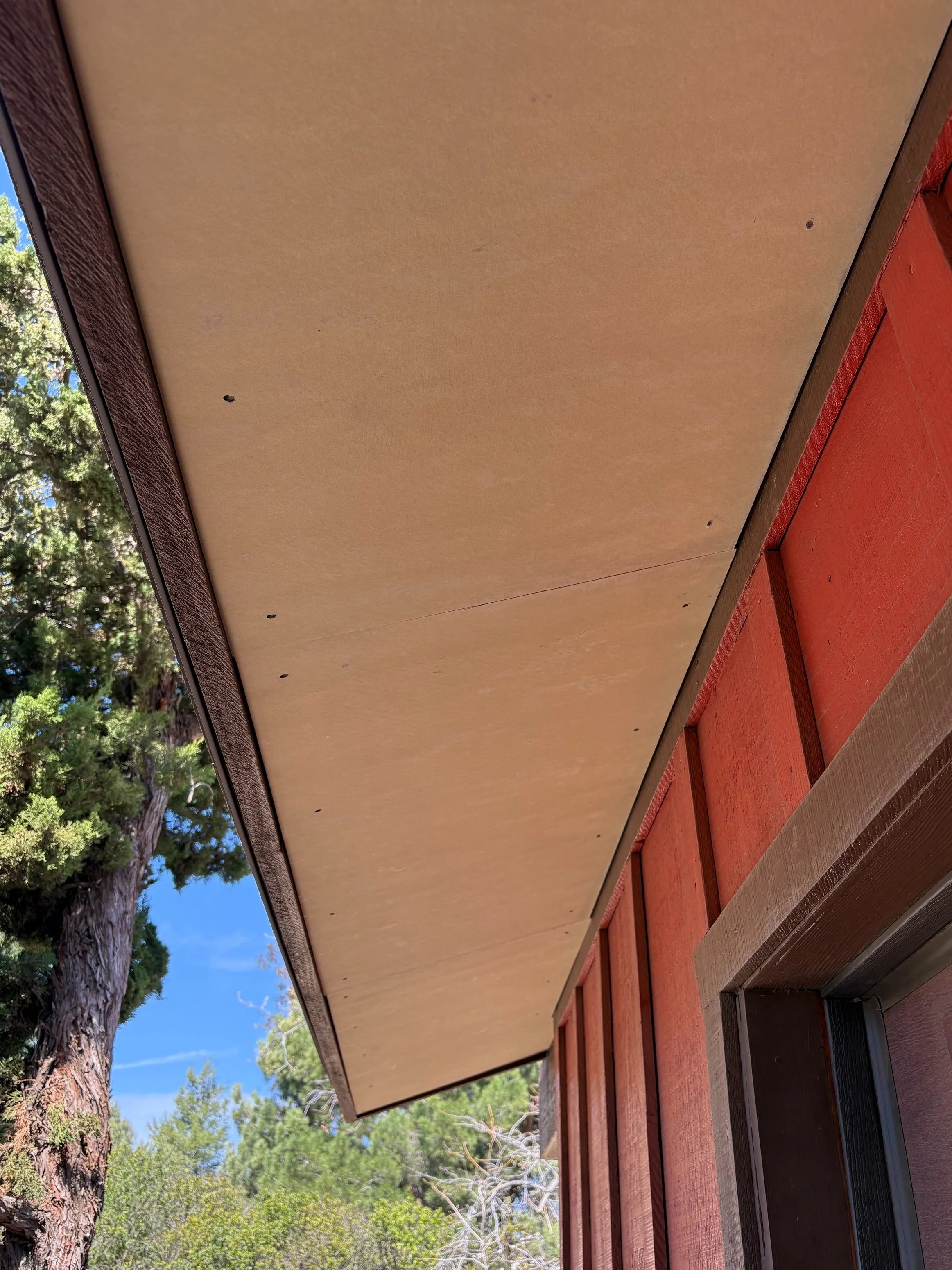 Fireproofing residential eaves to protect home from wildfires with fire-resistant materials.