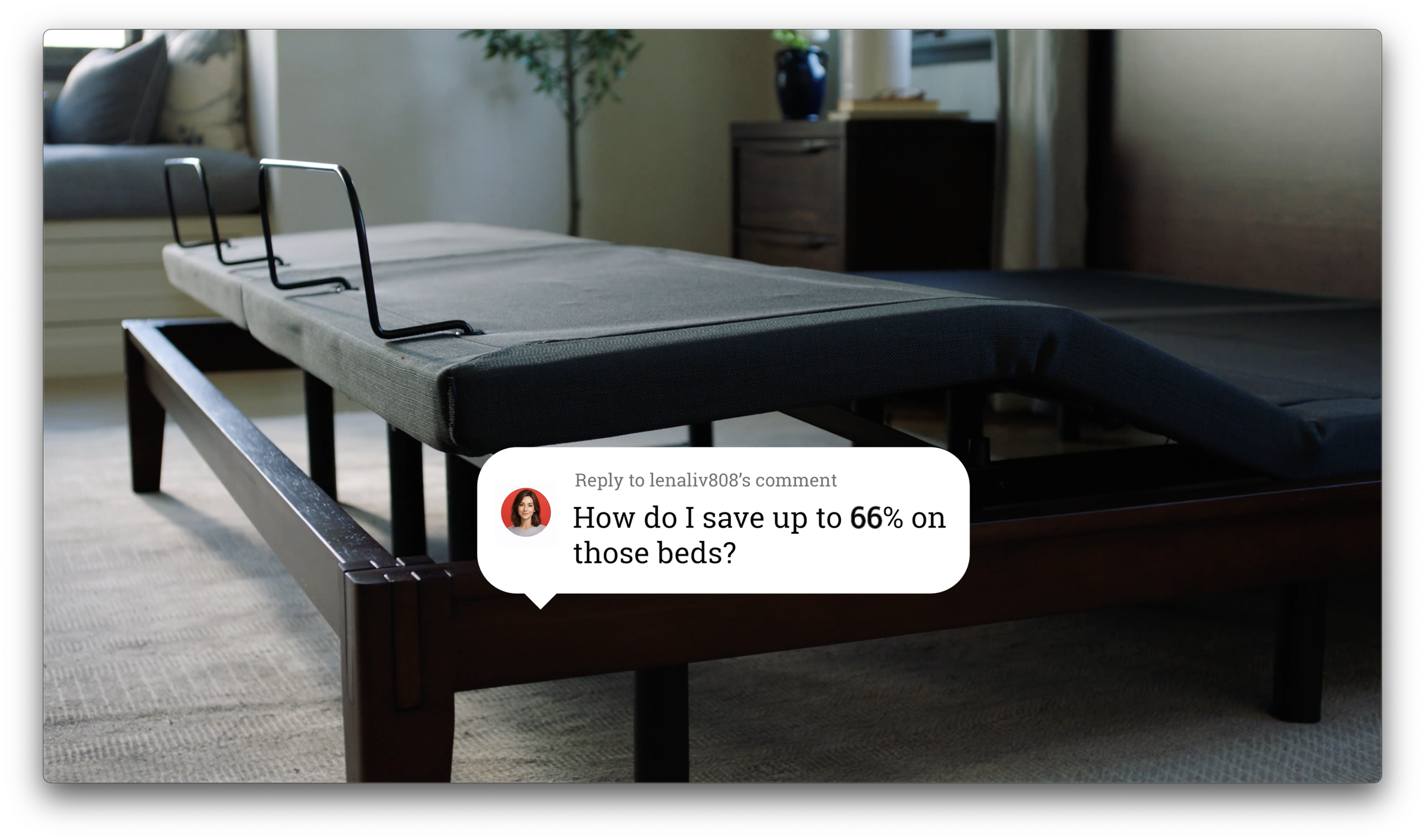 A modern bedroom with a black metal bed frame and a padded mattress, a sofa with pillows, a wooden nightstand with a blue vase, and a potted plant in the background.