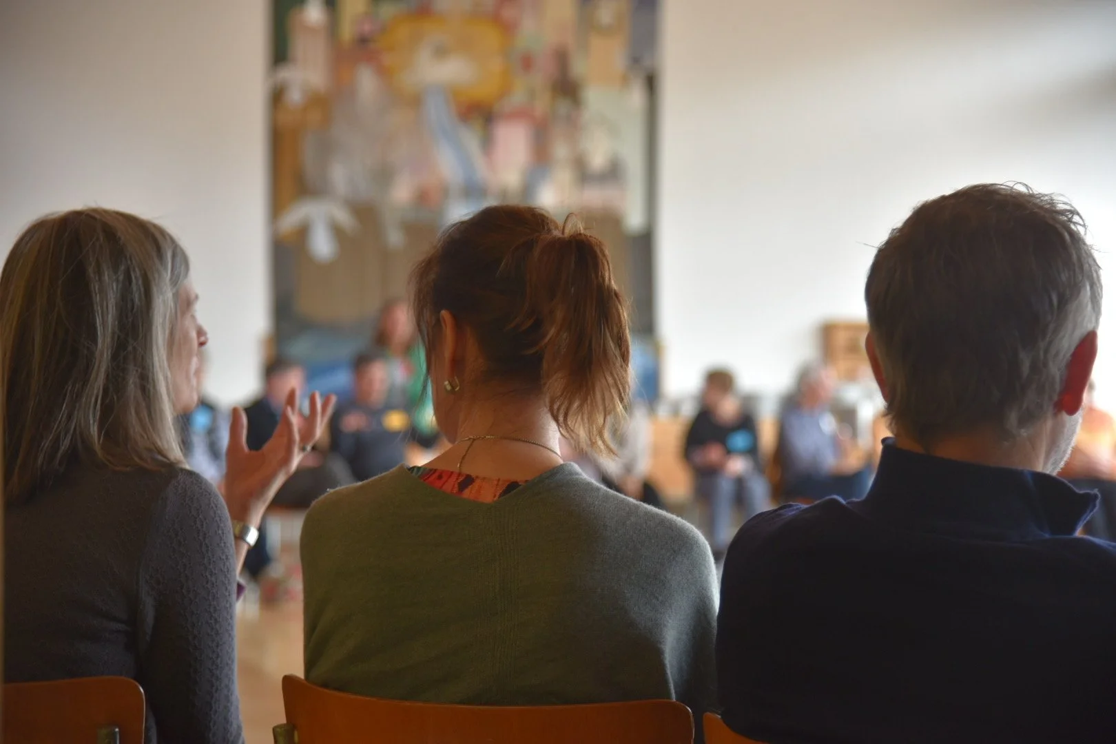 Menschen sitzen in einem Raum und nehmen an einer Diskussion oder einem Treffen teil.