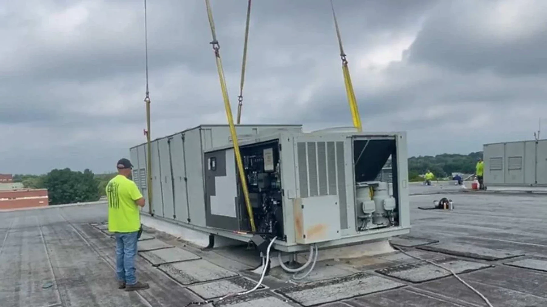 An ACS Services team member inspecting a large commercial HVAC unit.