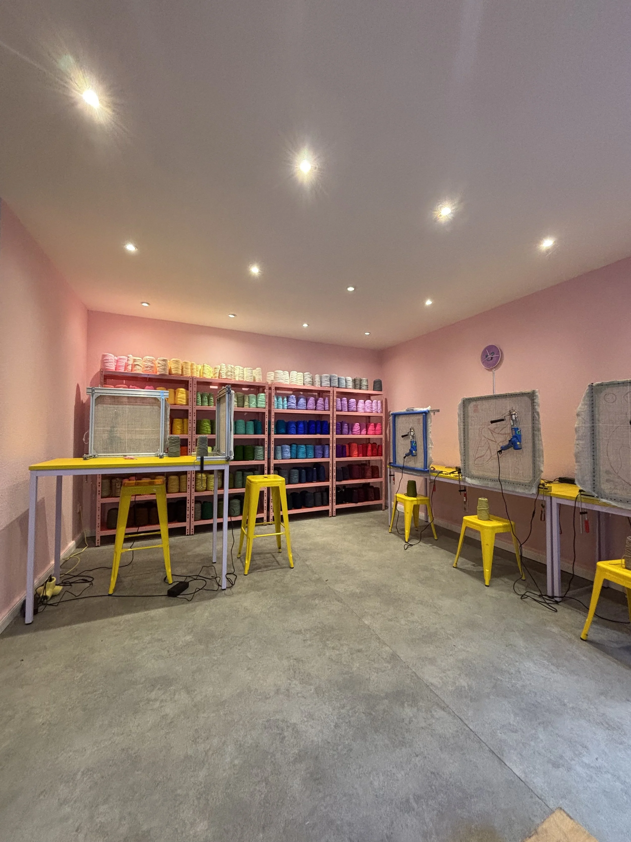 A colourful tufting studio, Tuft Tuft Berlin, featuring the location's signature colourful yarn wall