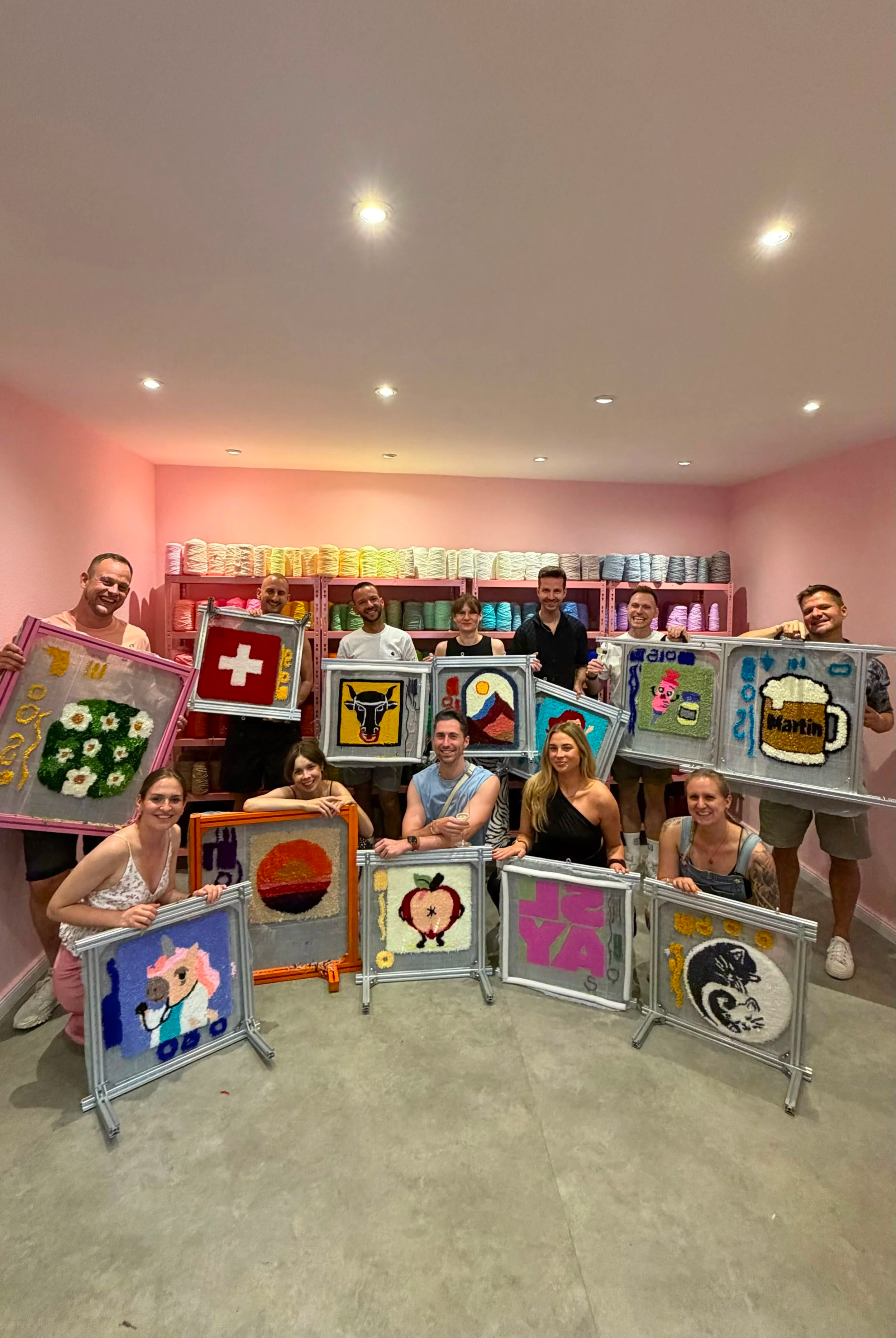 A group of friends hold up their tufted rugs, created at a Tuft Tuft Berlin workshop