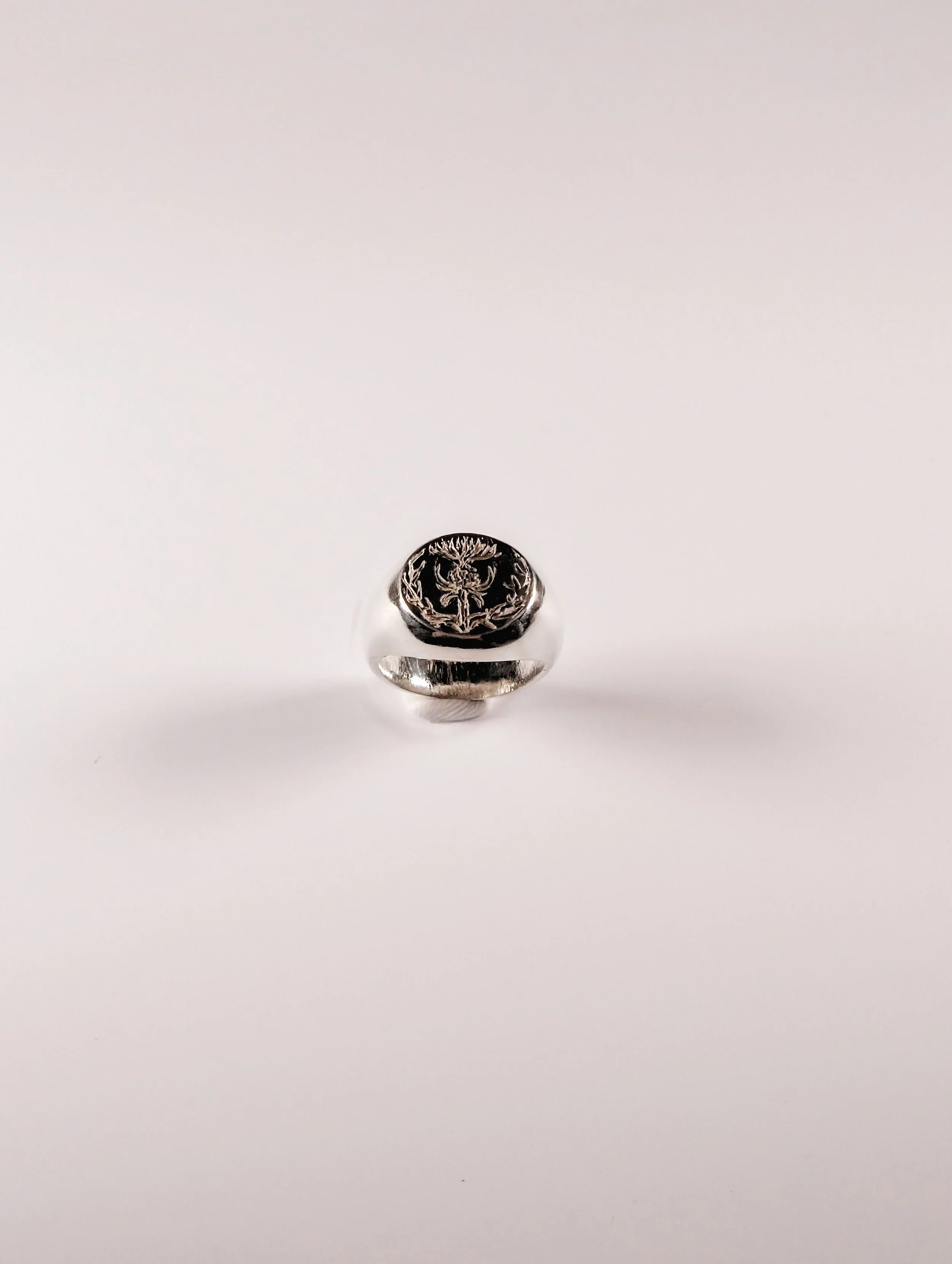 Polished silver signet ring created at a jewellery making workshop at Tuft Tuft, three-quarter view