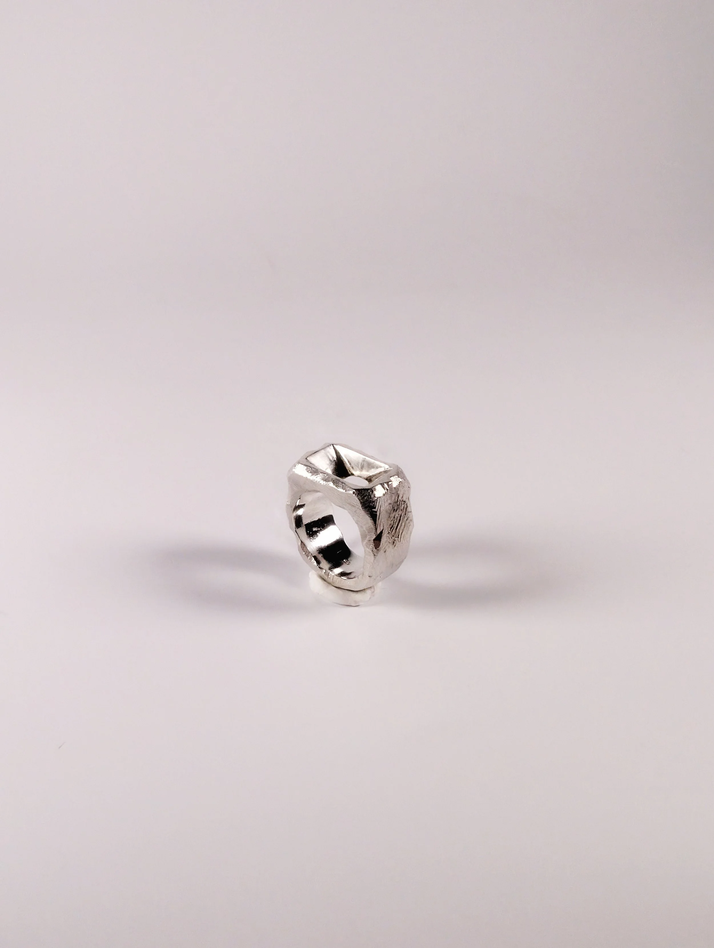 Polished signet sterling silver ring with a sunken design, three-quarter view