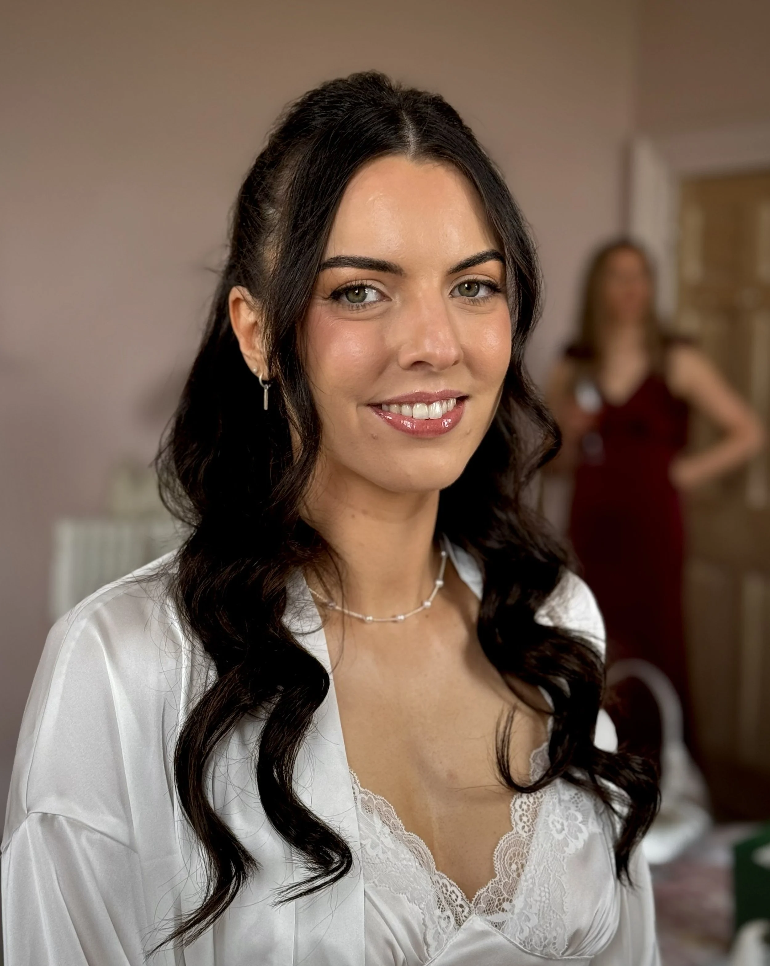 Wedding morning preparation featuring bridesmaid hair and makeup styling before the ceremony.