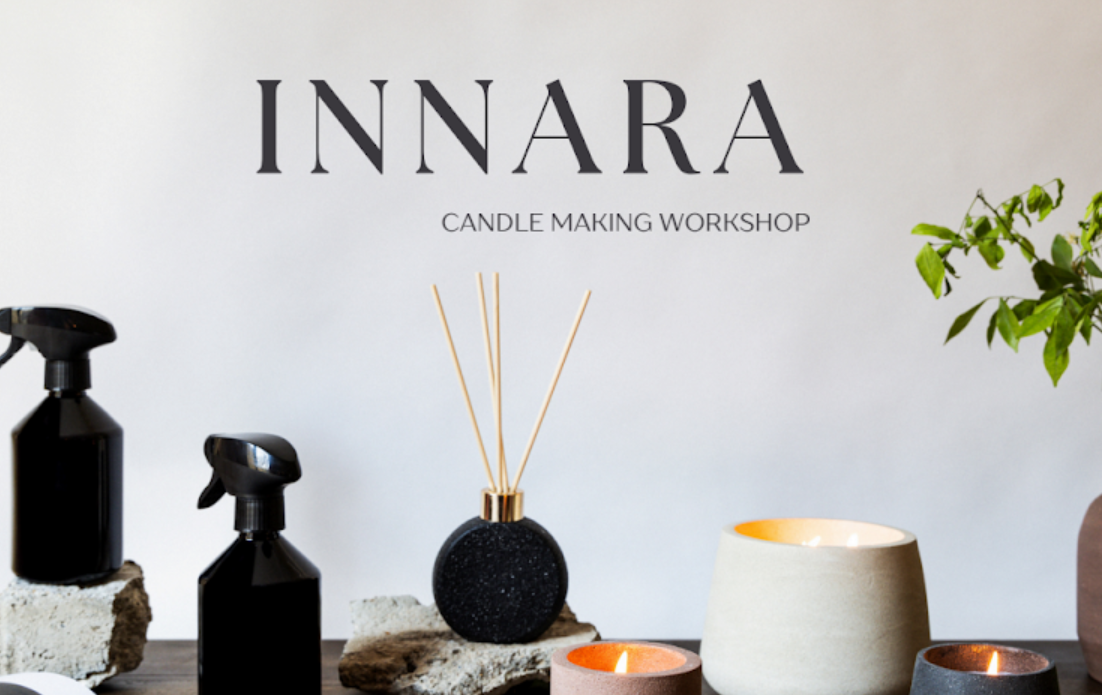 Display of candle making tools and candles at a workshop labeled 'Innara Candle Making Workshop' on a white wall.