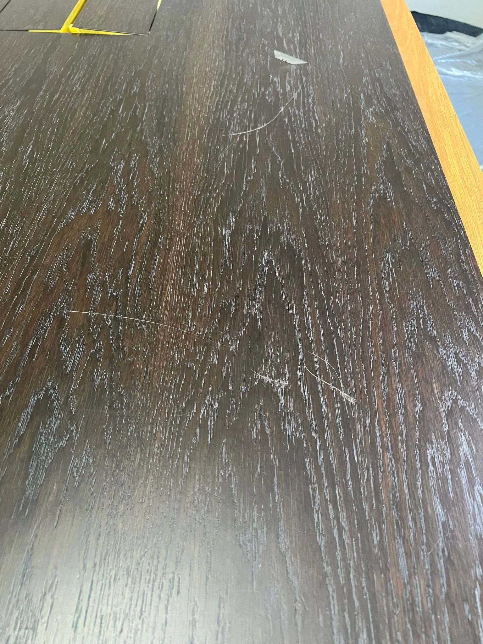 Dark wooden table with visible scratches and a yellow border.