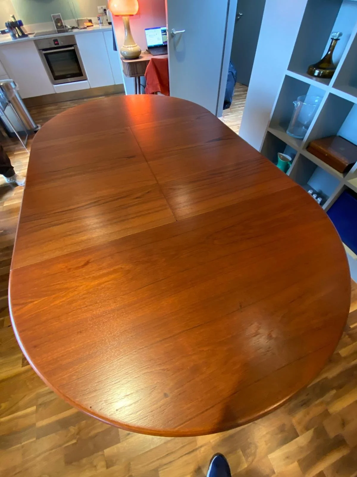A round wooden dining table with a glossy finish in a kitchen or dining area.