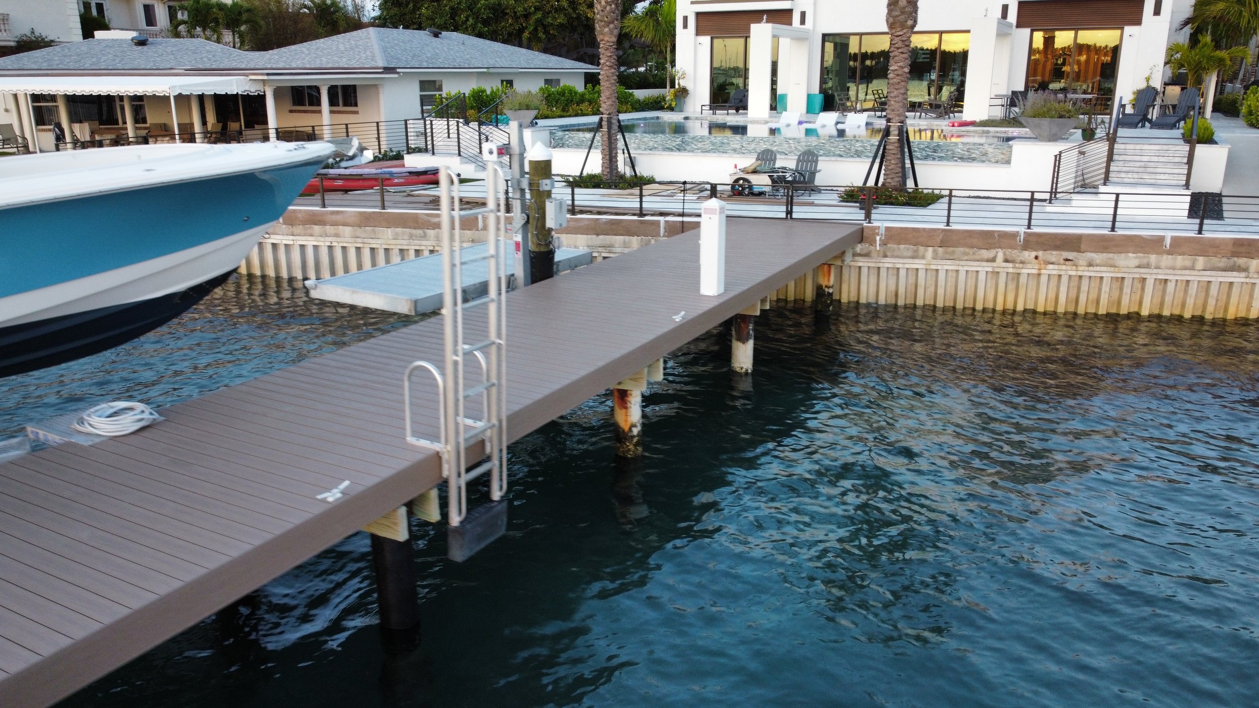 Architecturally integrated residential dock featuring premium decking and safety hardware, engineered to complement a luxury South Florida waterfront estate.