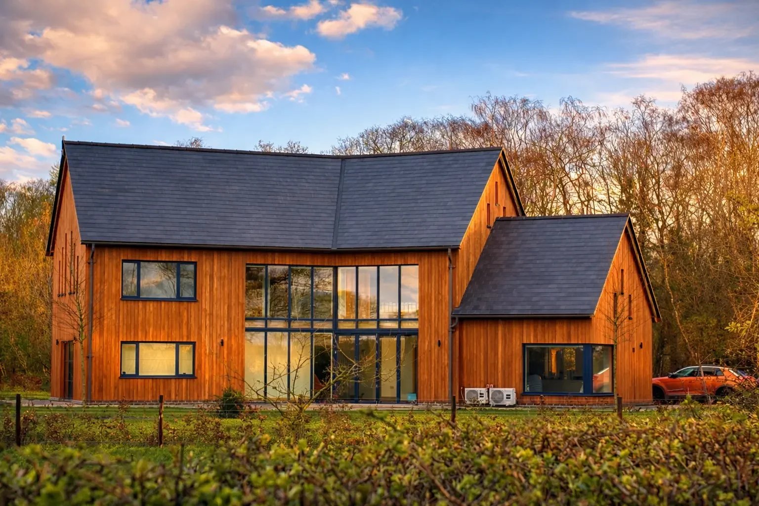 Modern wooden building with blue skies above and garden in front