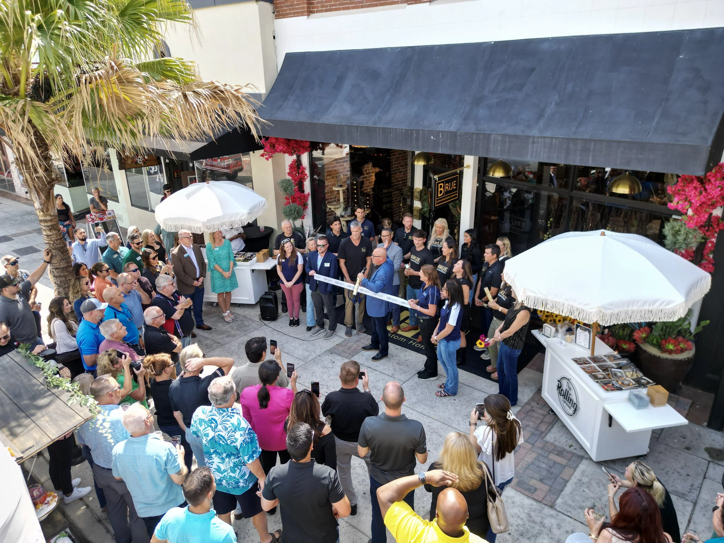 Aerial view of the crowd gathered for the Brije Custom Homes grand opening ribbon-cutting ceremony in downtown Ocala, Florida