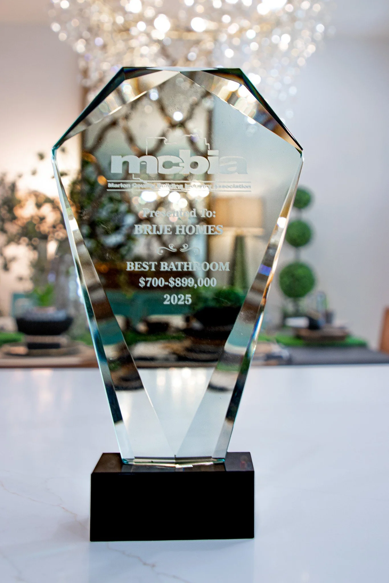 Crystal award trophy with engraving for 'Best Bathroom,' presented to Brije Homes, valued at $700-$899,000, for the year 2025.