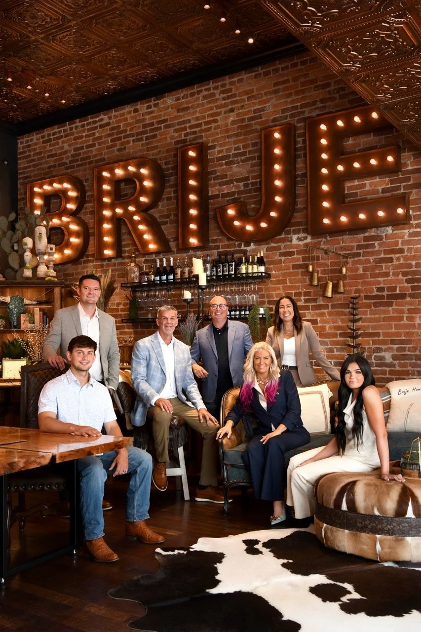 The Brije Custom Homes team in front of the lighted Brije sign