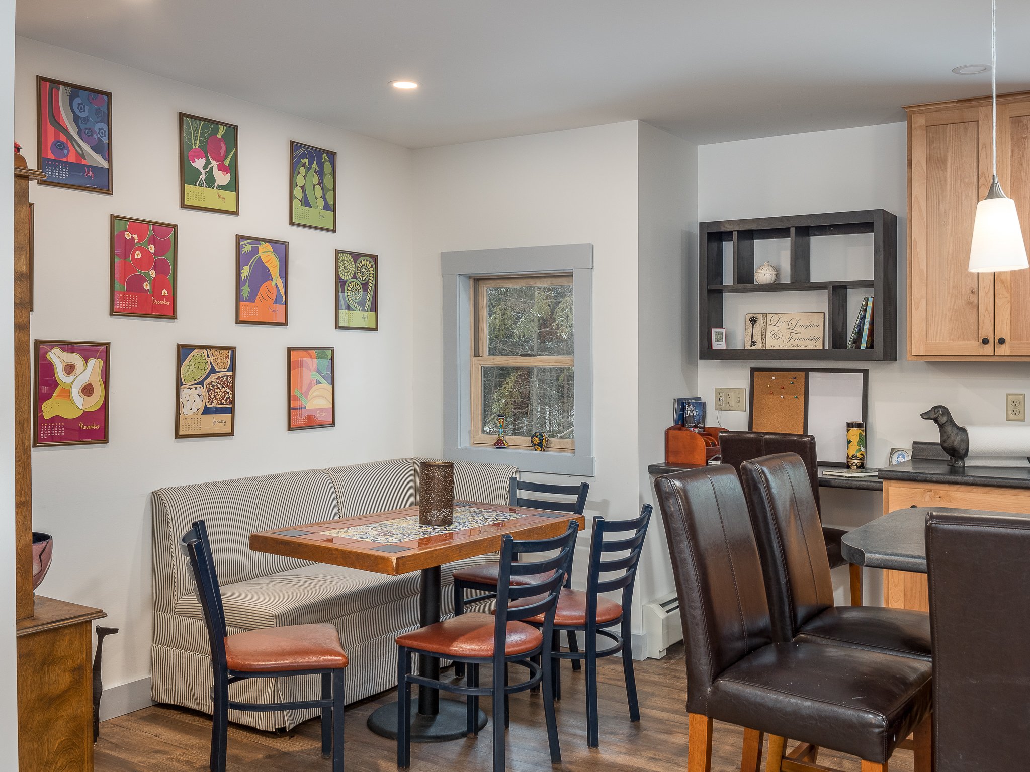 Dining area with wooden table, chairs, and framed artwork on walls.