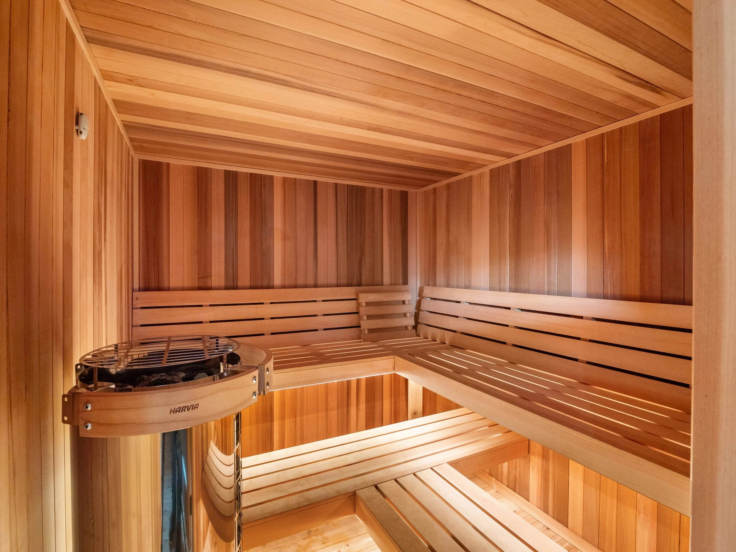 Interior of a wooden sauna with benches and a heater.