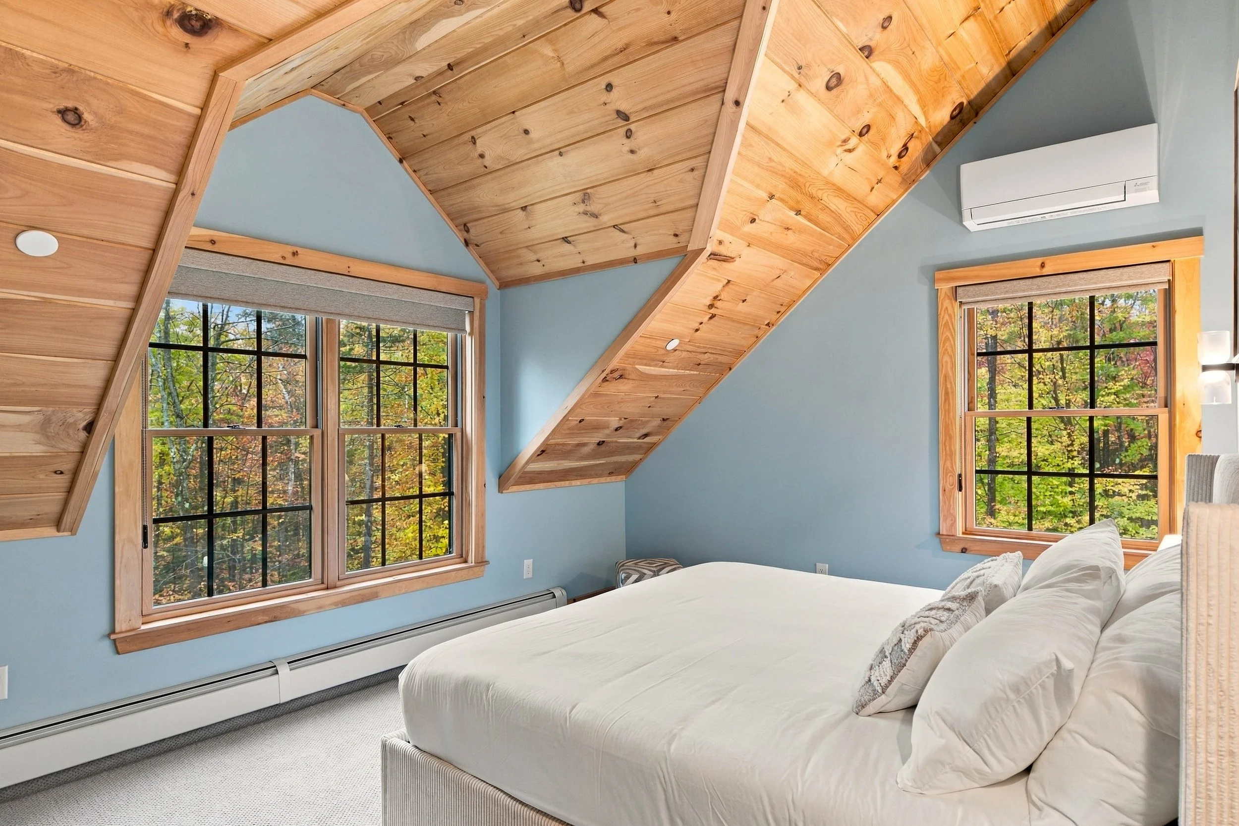 Wake up to peaceful wooded views in this charming king bedroom with dramatic vaulted ceilings and warm mountain character.