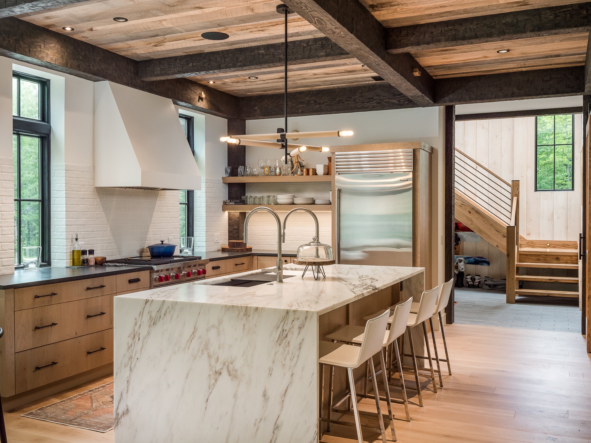 Modern kitchen with marble island, wood cabinets, and stainless steel appliances
