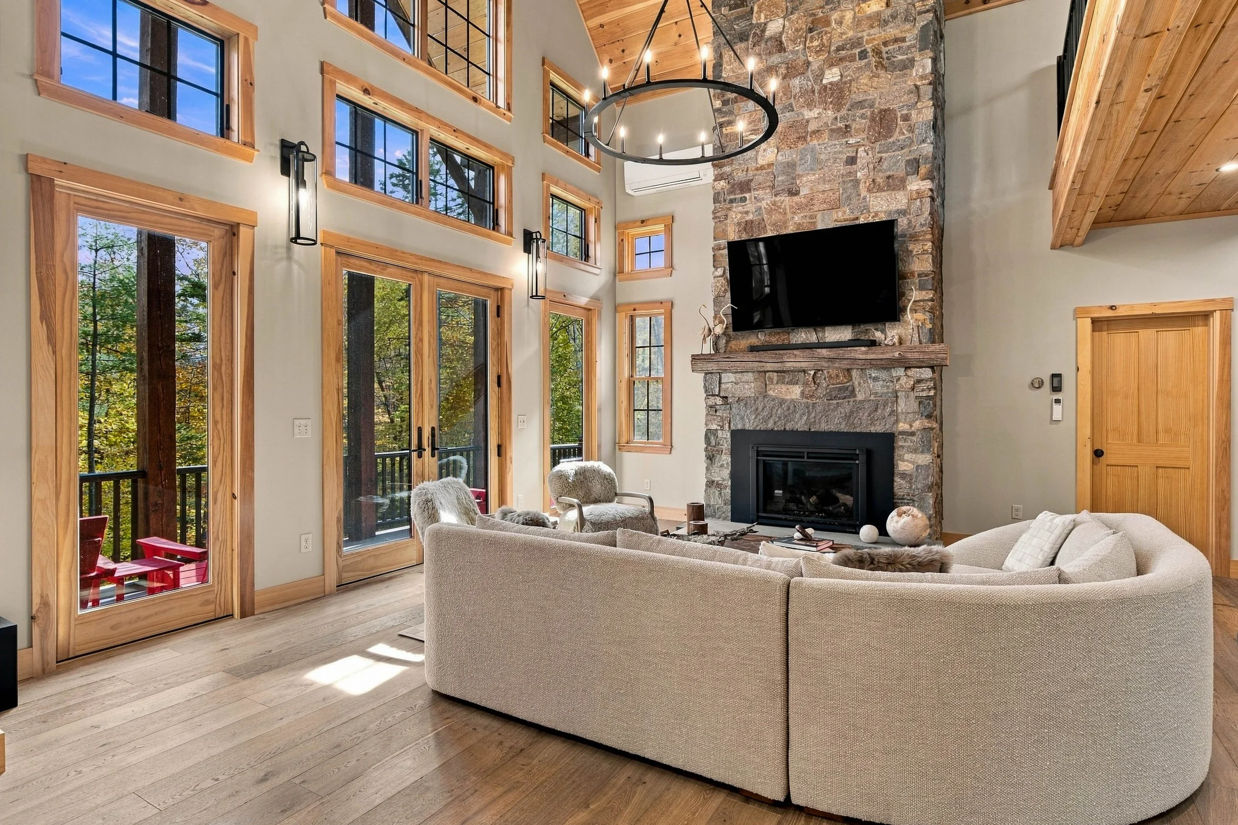 A dramatic floor-to-ceiling stone fireplace anchors the grand living room, bringing warmth and mountain character to every stay. 