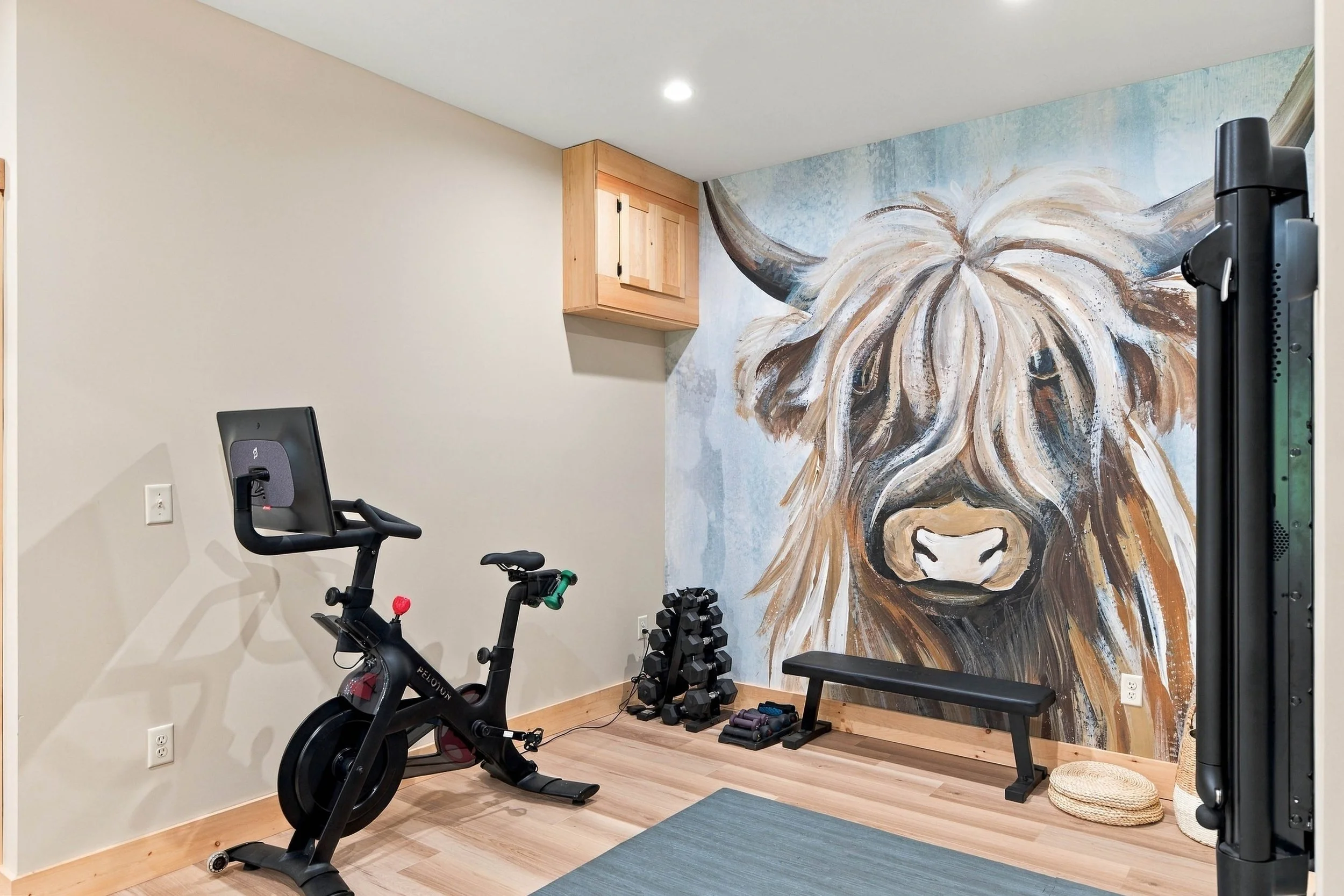 Keep up with your fitness routine in the private home gym, featuring a Peloton bike, Tonal system, and free weights.