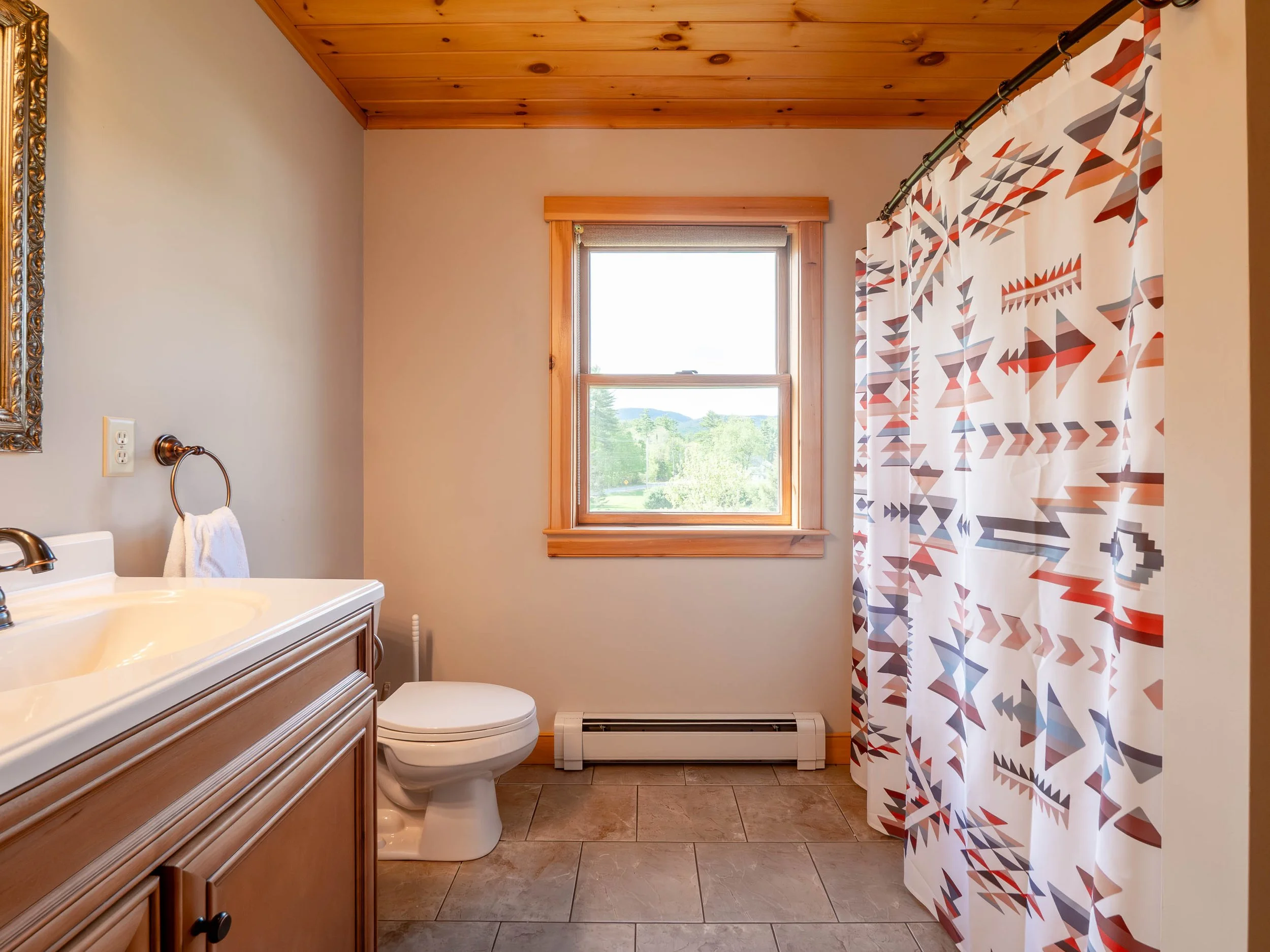 Private primary ensuite bathroom at The Lone Star at Sunday River vacation rental in Sunday River area minutes from the slopes with bathtub and shower
