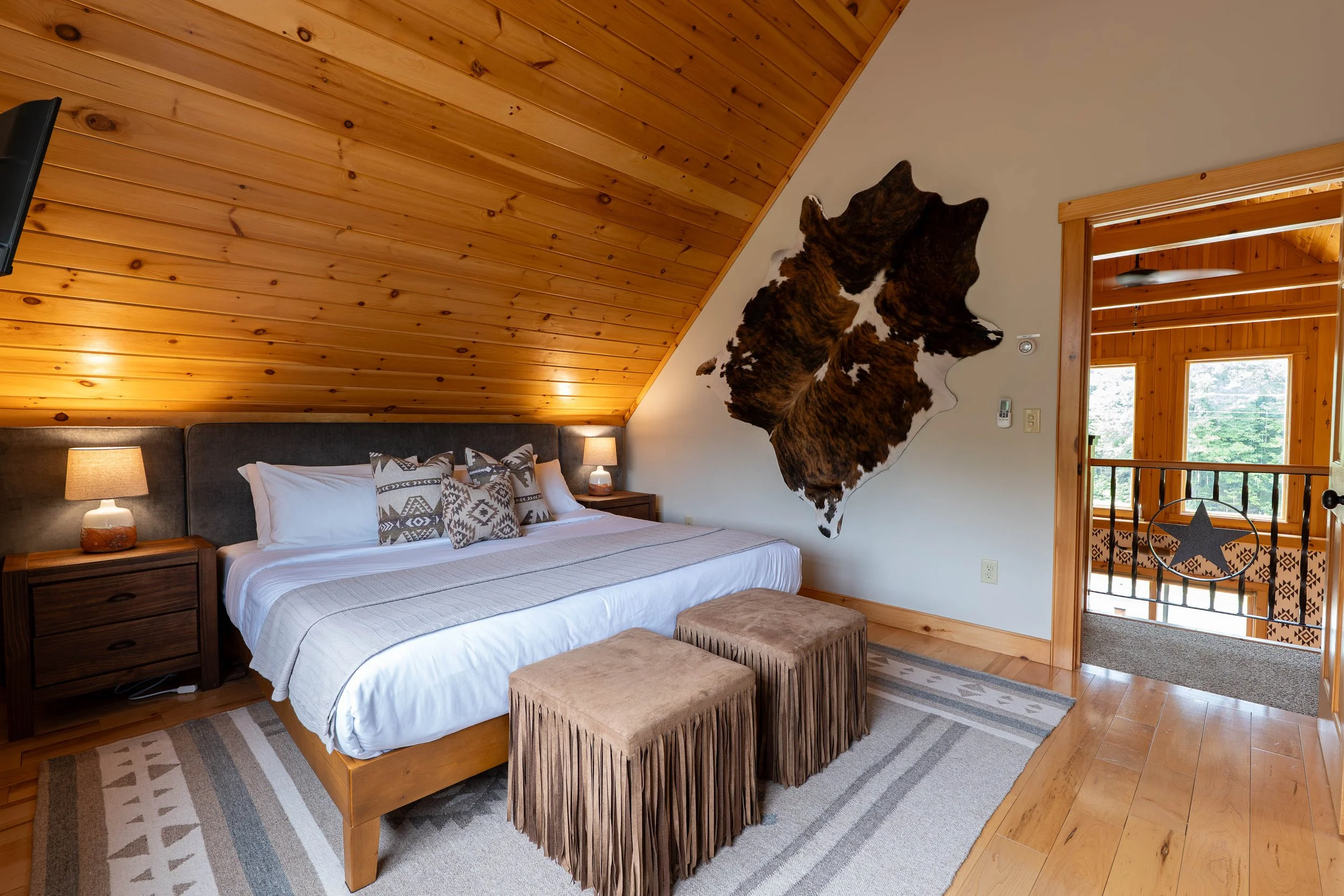 Stylish primary bedroom at The Lone Star at Sunday River chalet in Sunday River area for a Western Maine getaway with king bed and ensuite bathroom