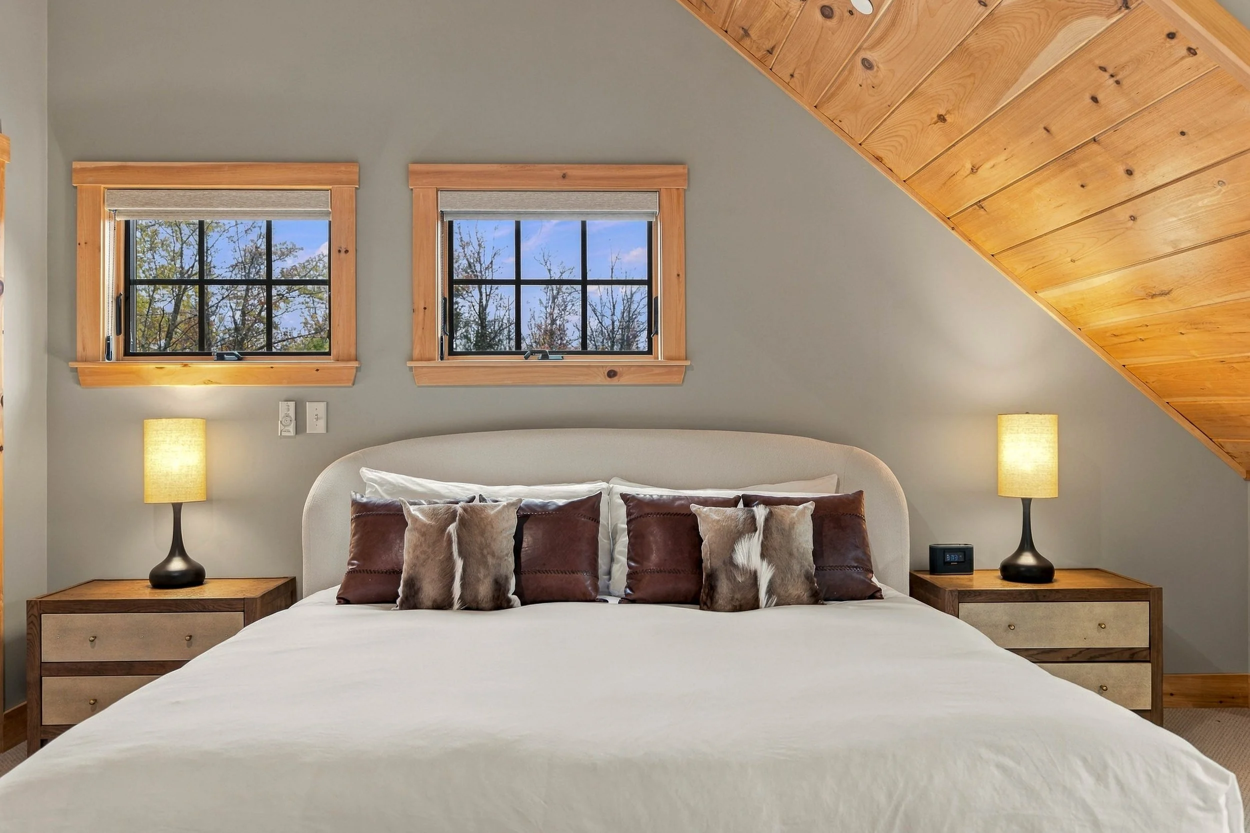Wake up to peaceful woodland views from your comfortable king bed, tucked beneath warm vaulted ceilings.